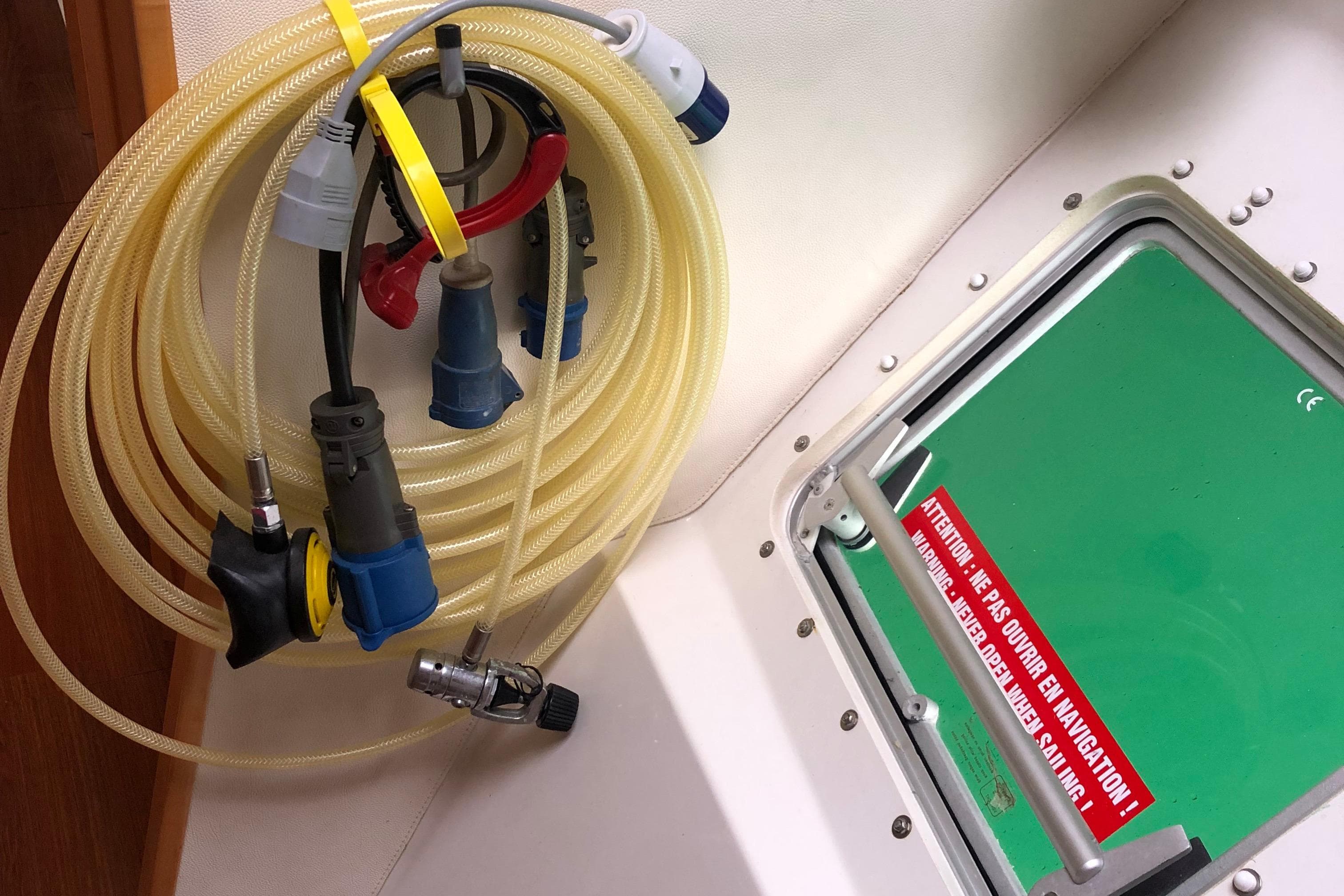 Coiled hoses and connectors on Fountaine Pajot Salina 48, 2008 model, near a green hatch.
