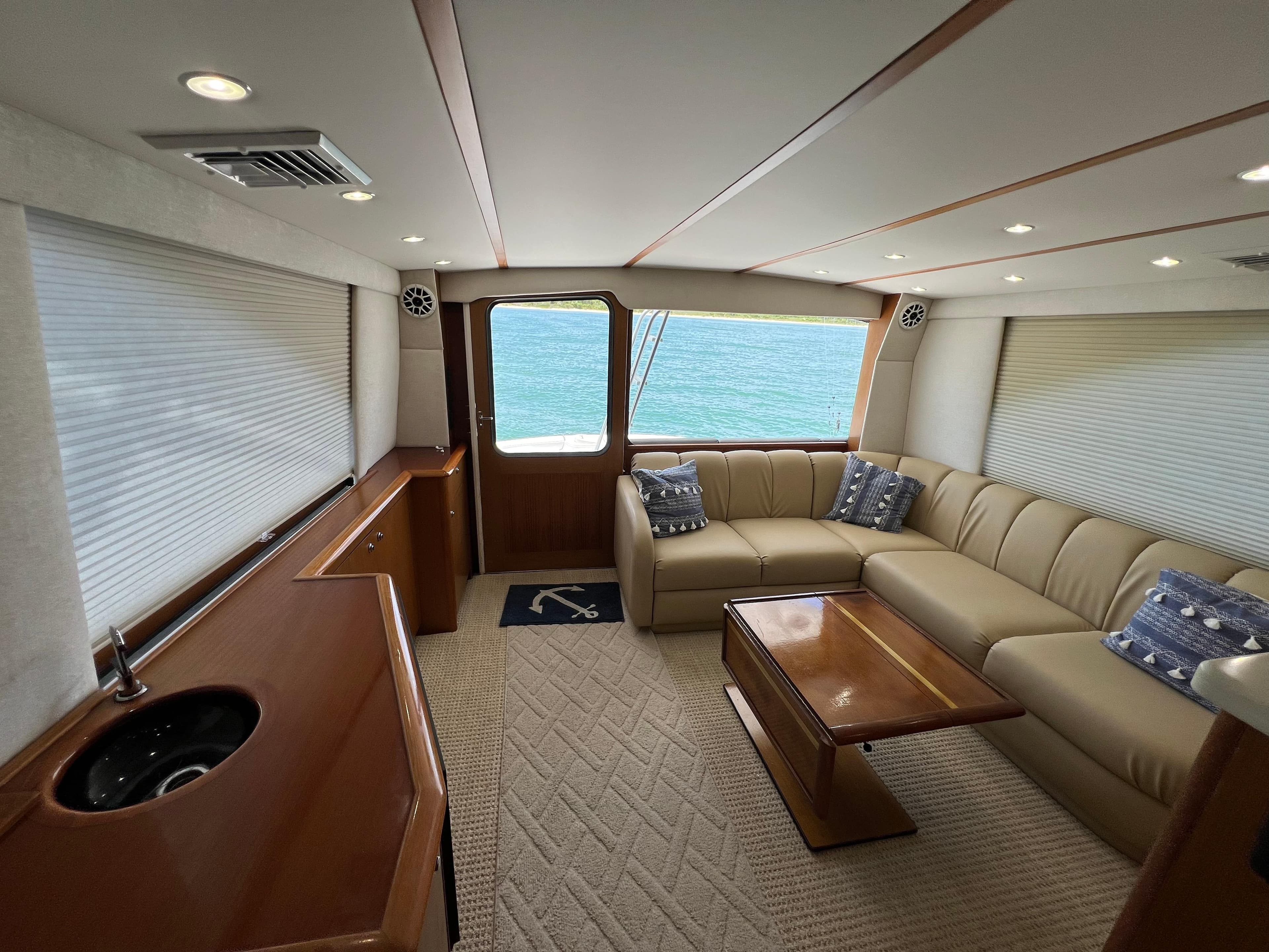Luxurious interior of 2001 Ocean 52 Convertible yacht with beige seating and ocean view.