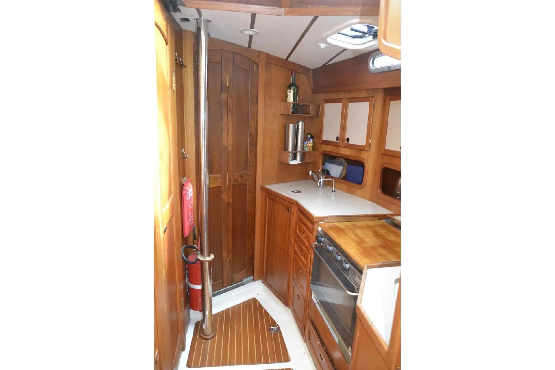 Interior of 1991 Nauticat 32 sailboat featuring a compact wooden kitchen area.