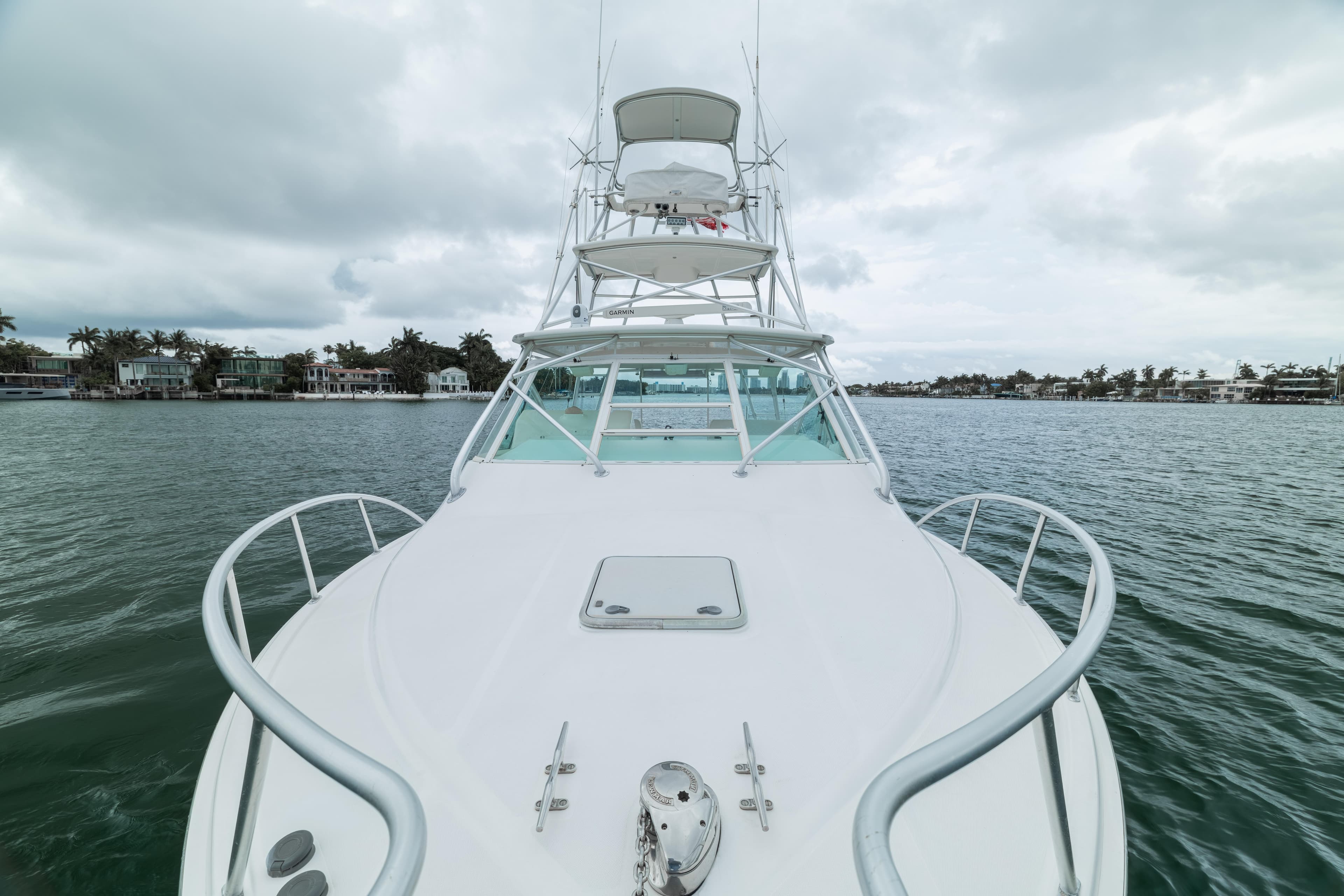 2006 Cabo 35 Express yacht on water, cloudy sky, coastal background.