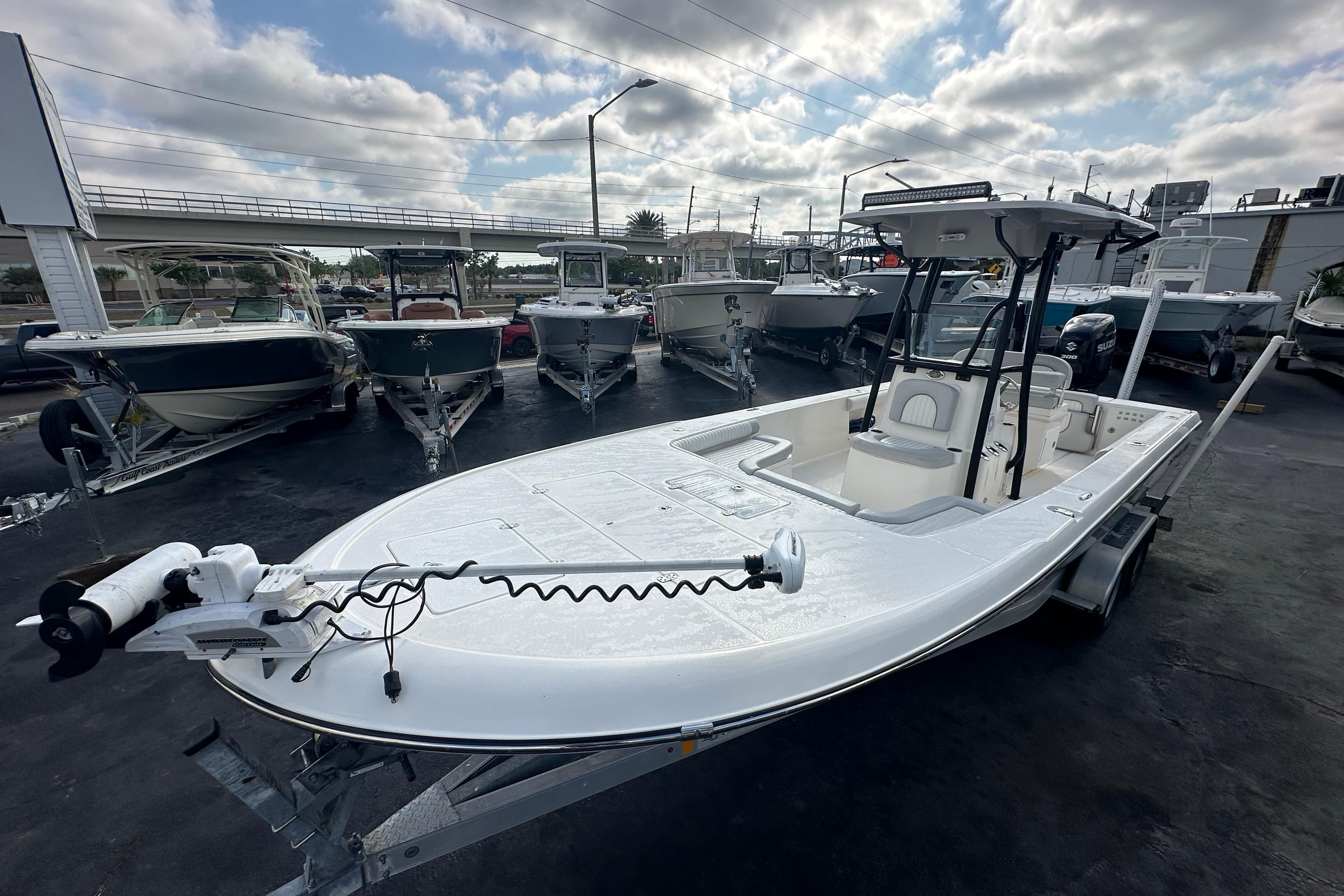 2018 Sea Born FX25 Bay boat on trailer, parked among other boats under cloudy sky.