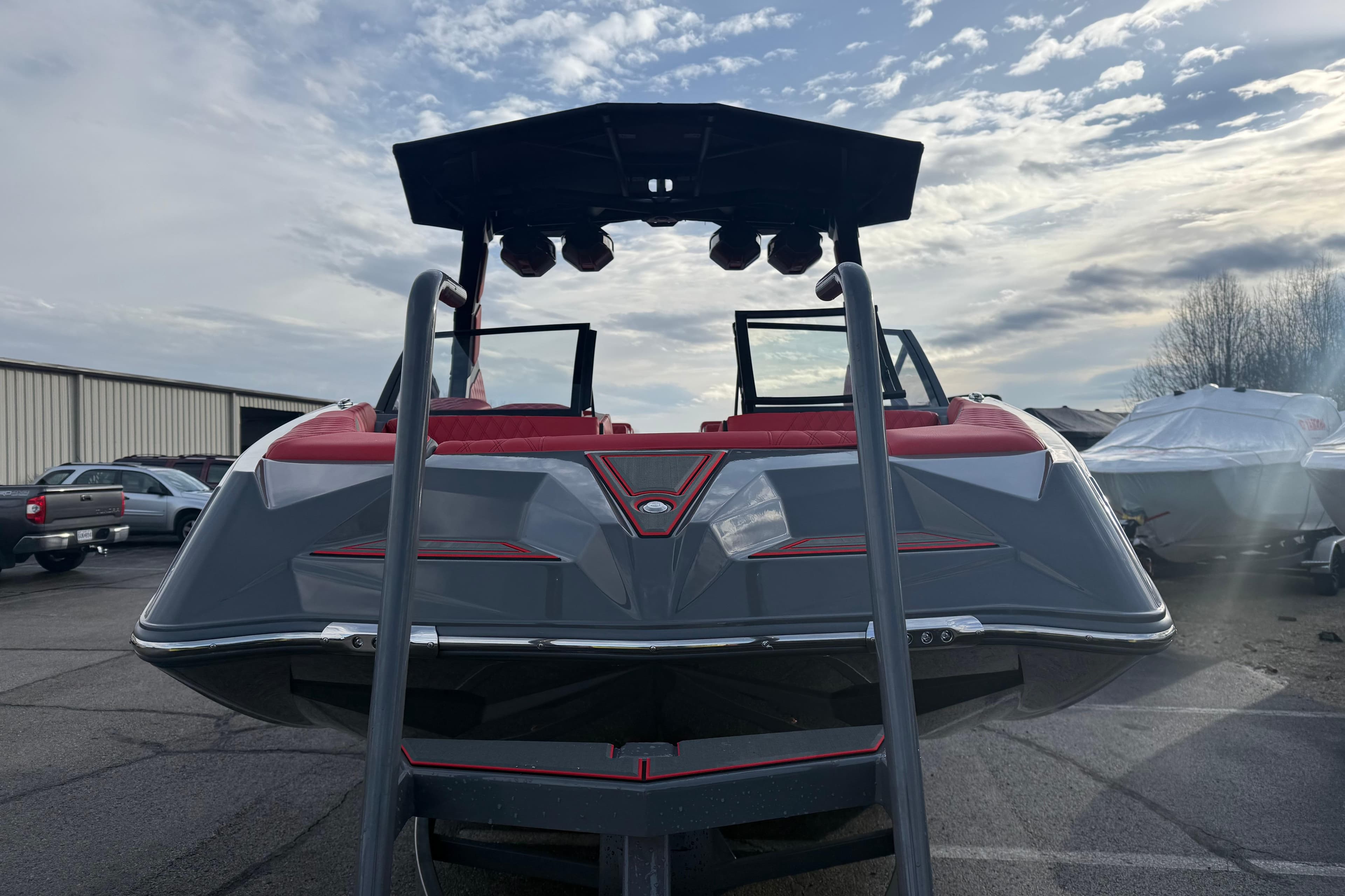 2026 Tigé 24RZX boat with sleek design, red and gray accents, parked outdoors.