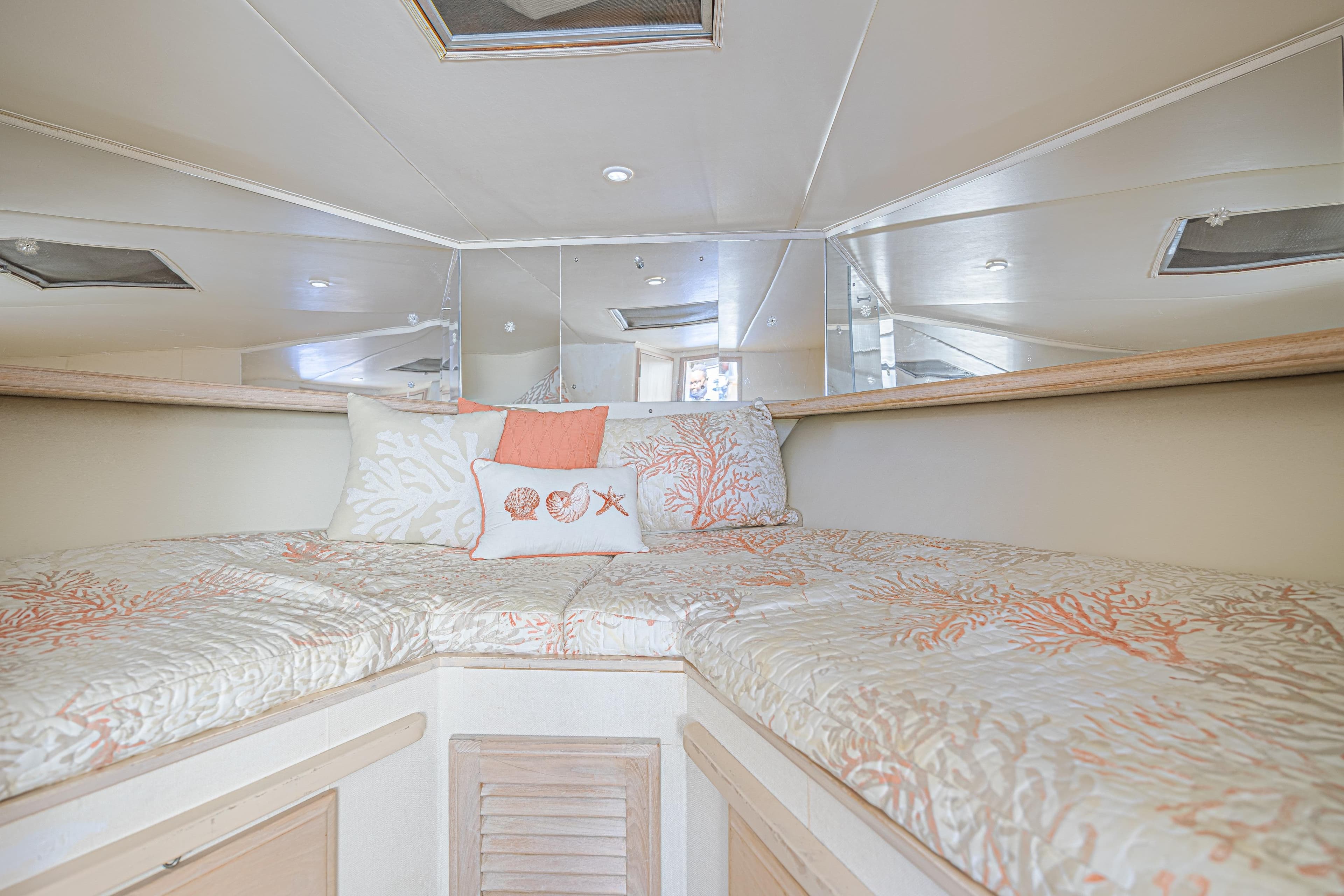 Cozy cabin interior of 1994 Tollycraft 45 Cockpit Motor Yacht with coral-themed bedding.