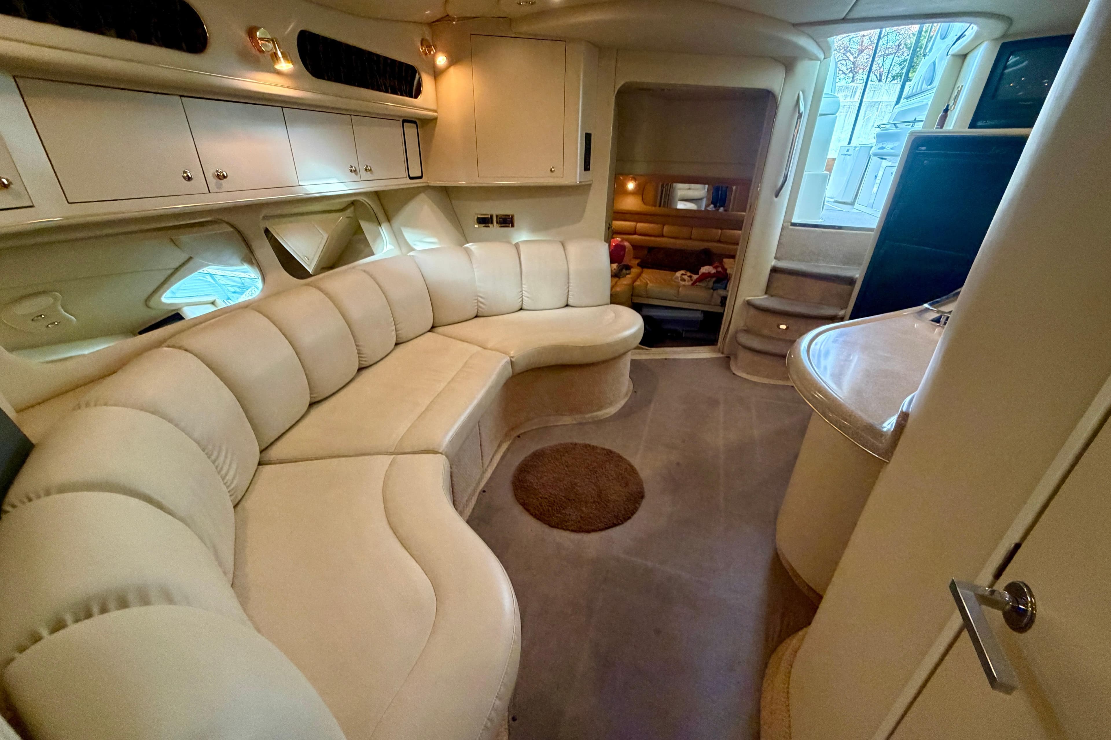 Luxurious interior of a 1999 Sea Ray 400 Sundancer yacht with plush seating.