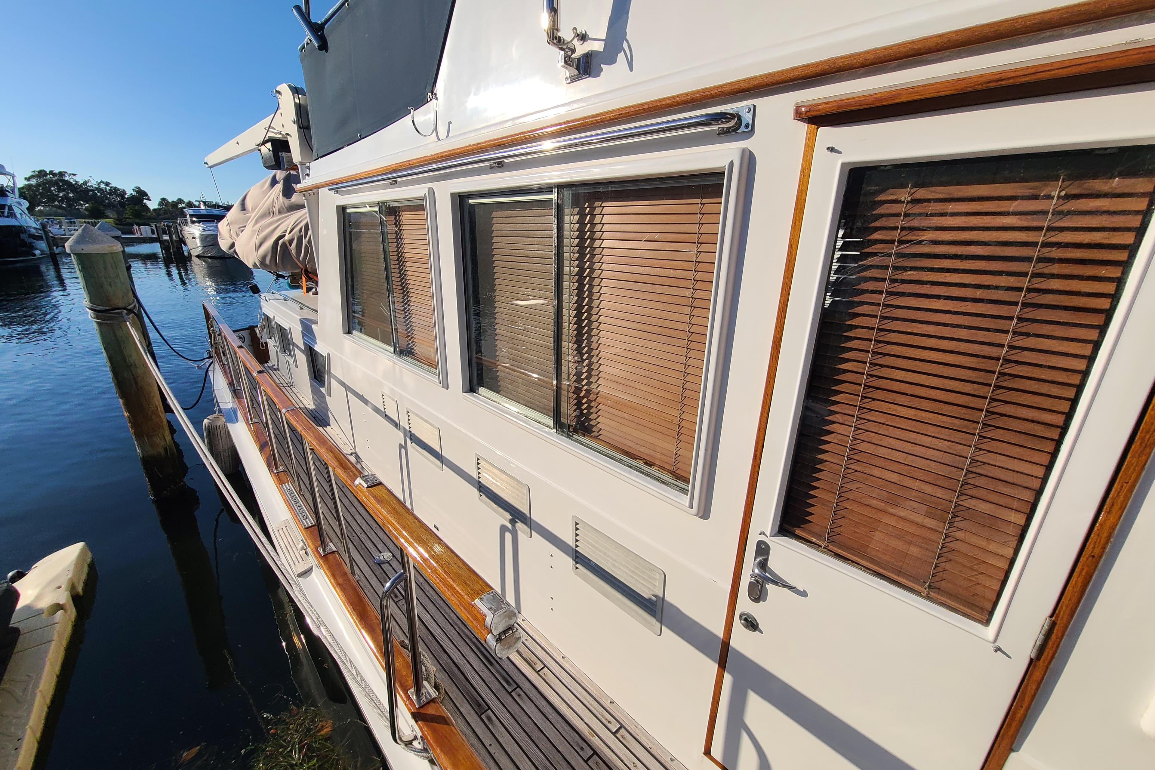 Grand Banks 46 Classic yacht, 2000 model, docked with wooden blinds and polished railings.