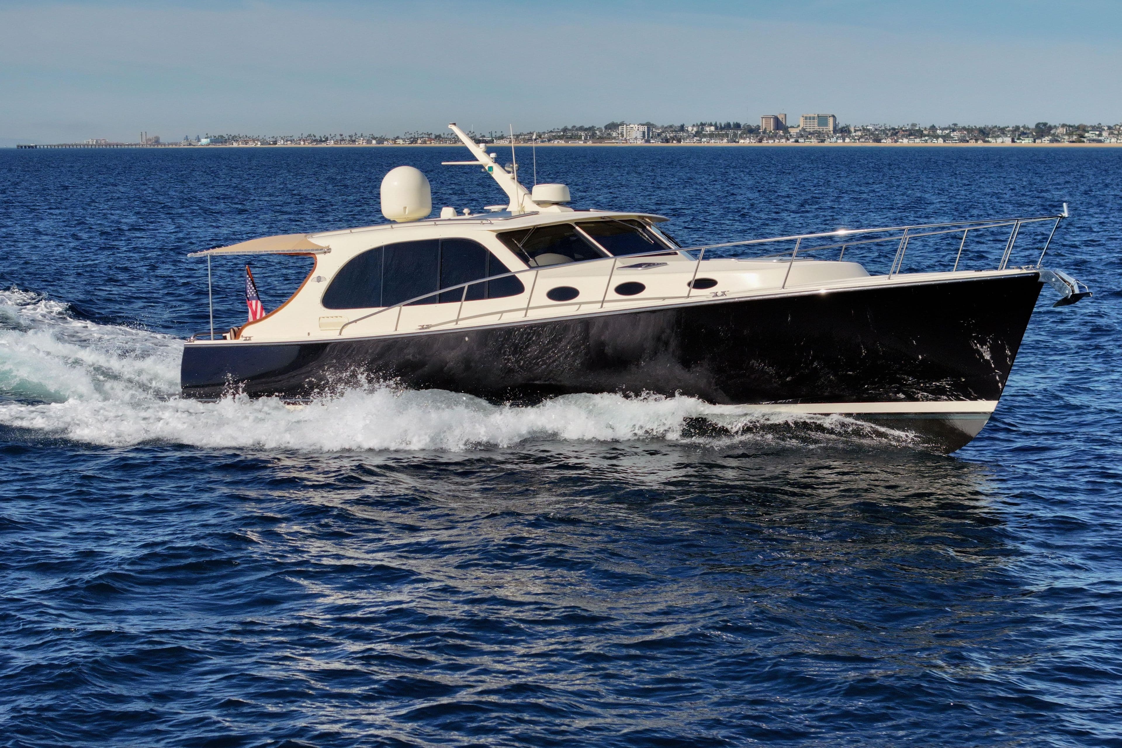 2015 Palm Beach Motor Yachts PB45 cruising on open water, cityscape in background.