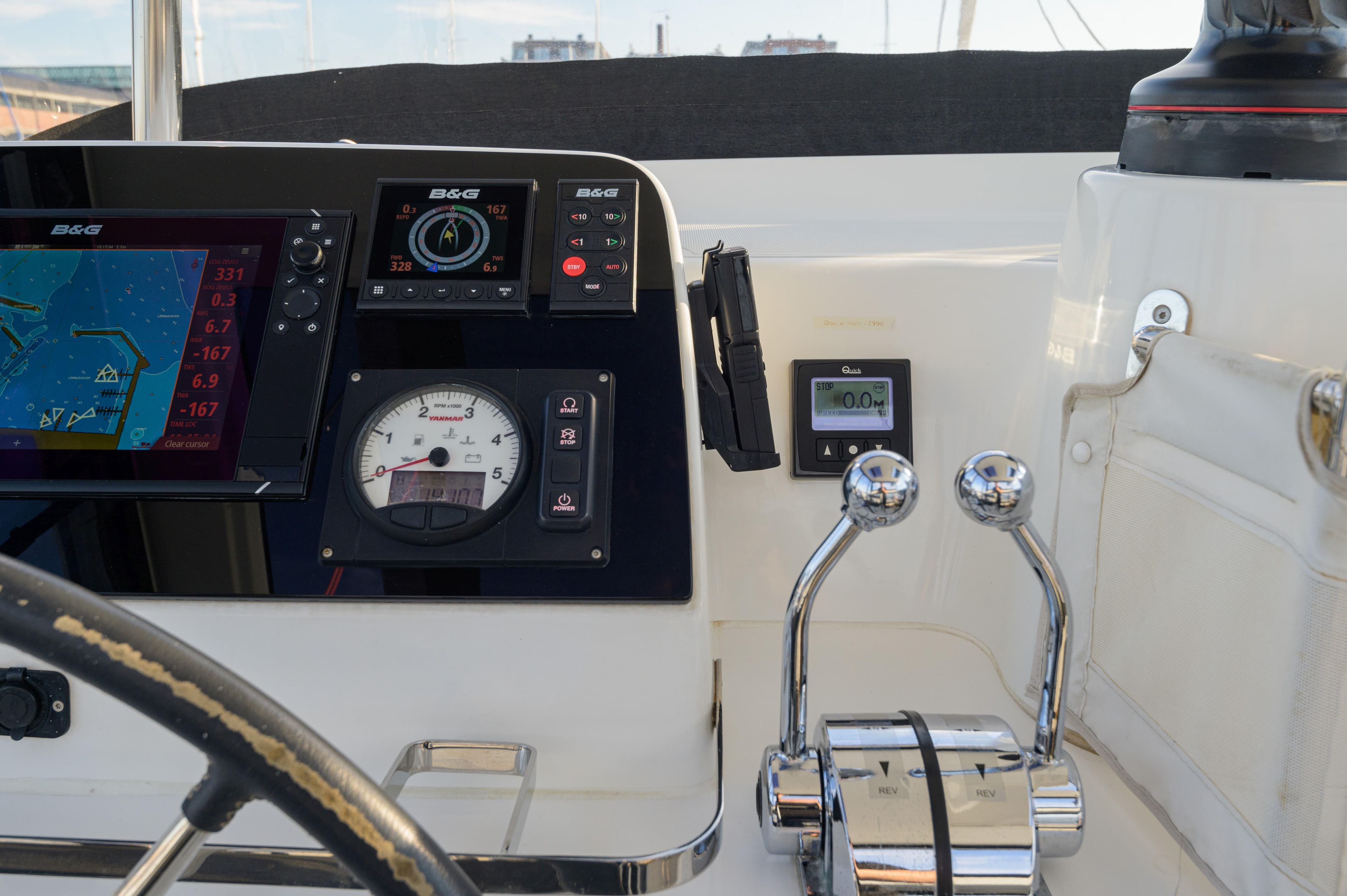 Helm of 2019 Lagoon 42 catamaran with navigation instruments and dual throttle controls.