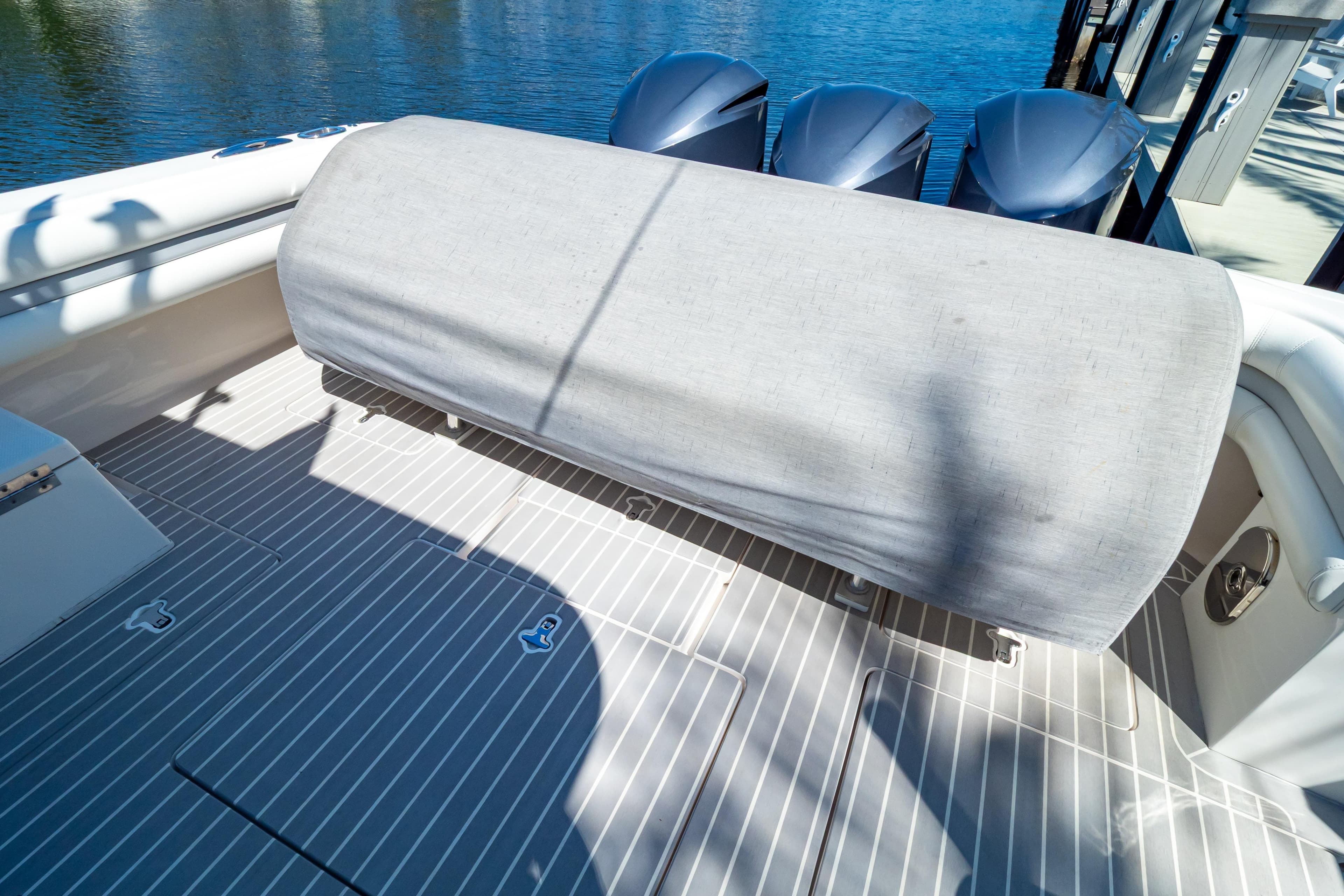 2016 Intrepid 400 Cuddy boat deck with covered seating and triple outboard engines.