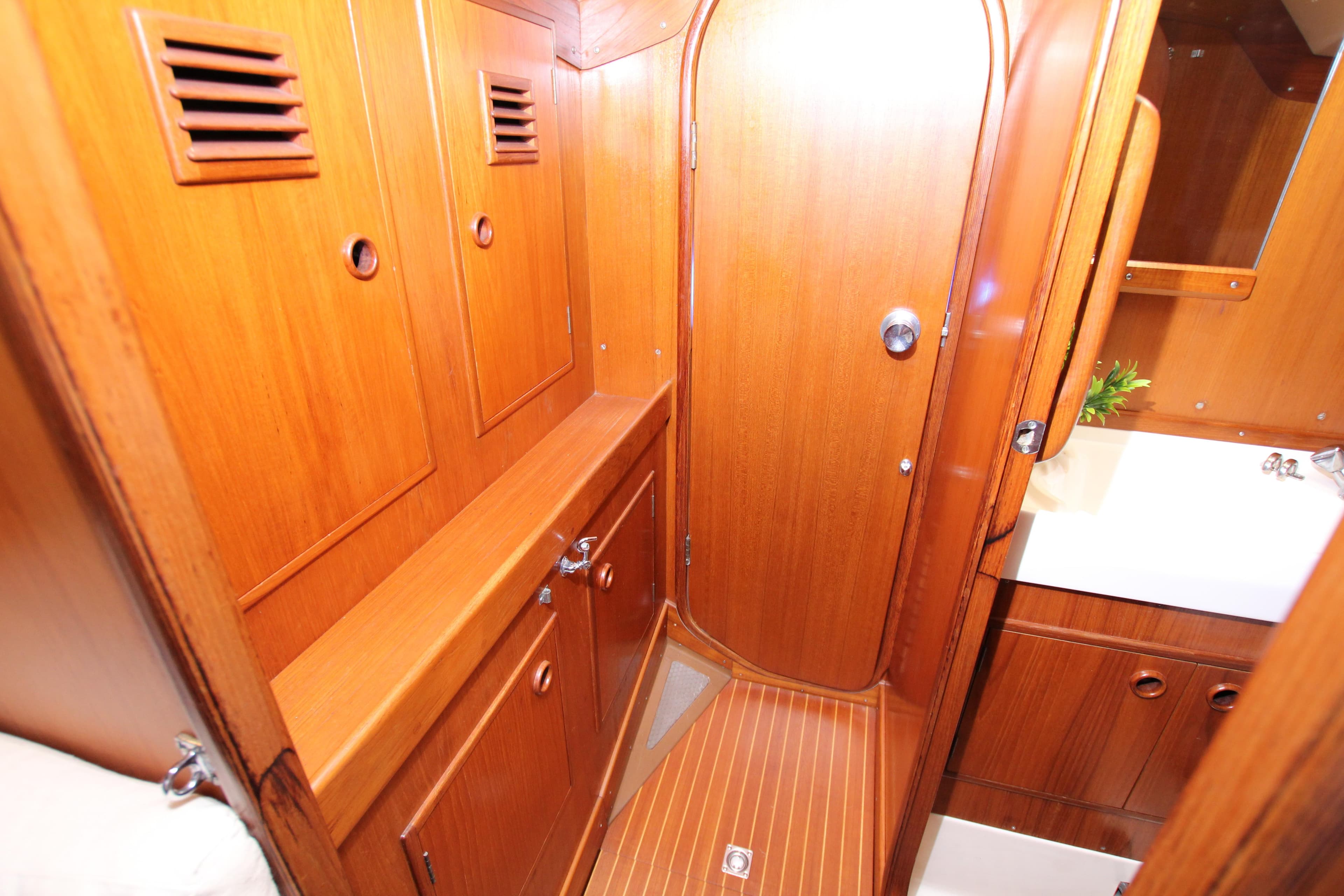 Interior of 1982 Nautor Swan 371 yacht, featuring wooden cabinetry and compact bathroom space.
