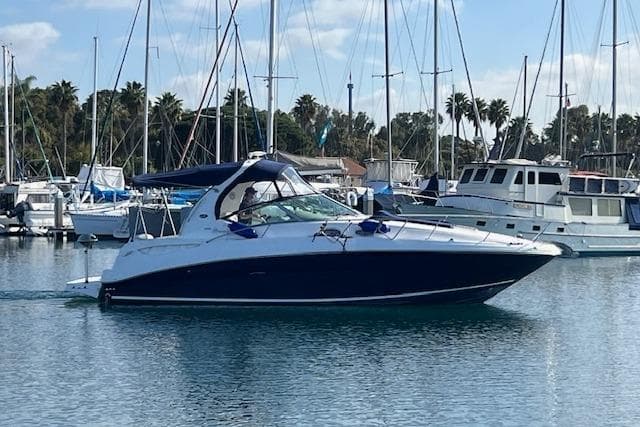 2005 Searay 320 boat docked in a marina with sailboats in the background.