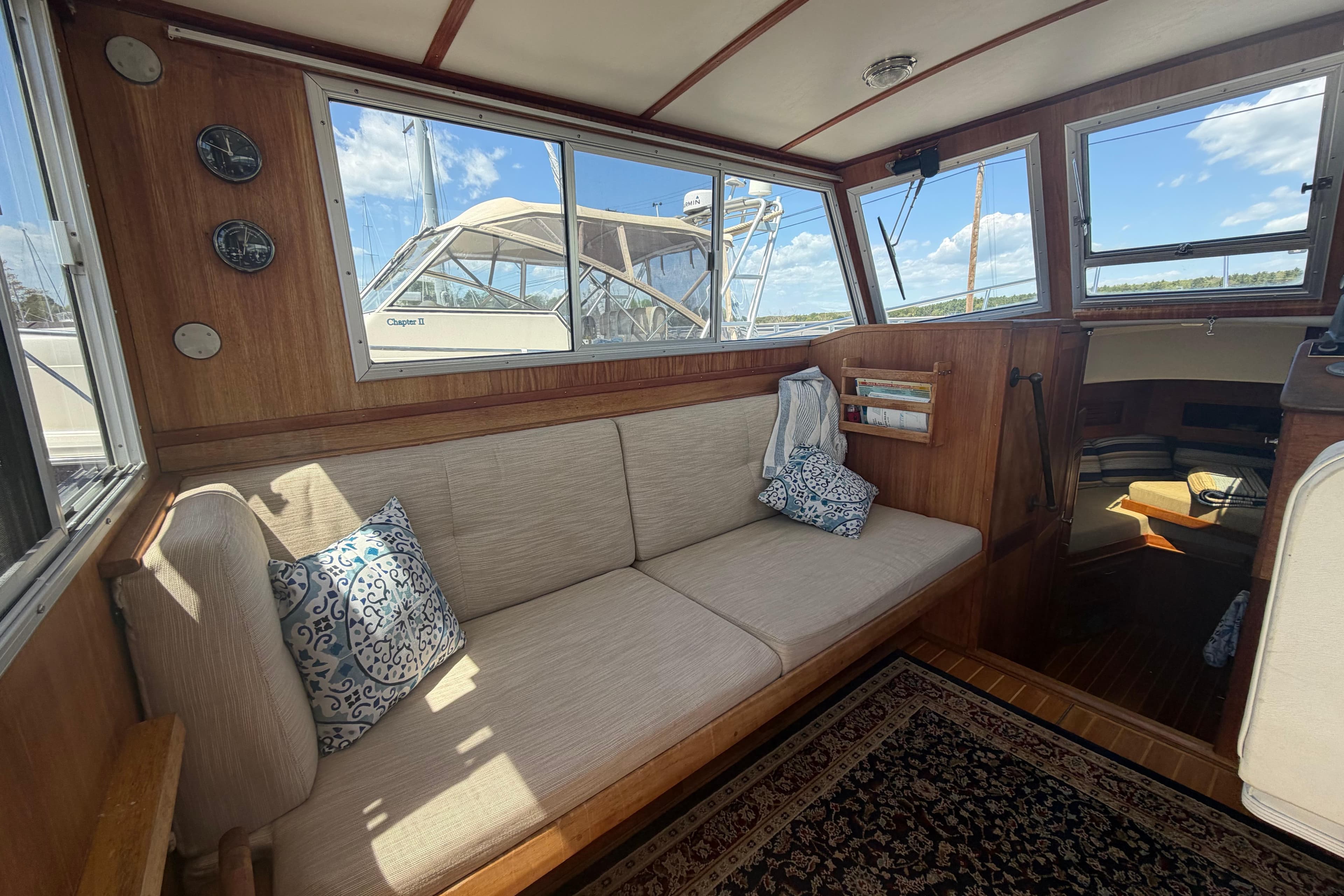 Interior of a 1990 Cape Dory 28 Flybridge boat with cozy seating and nautical decor.