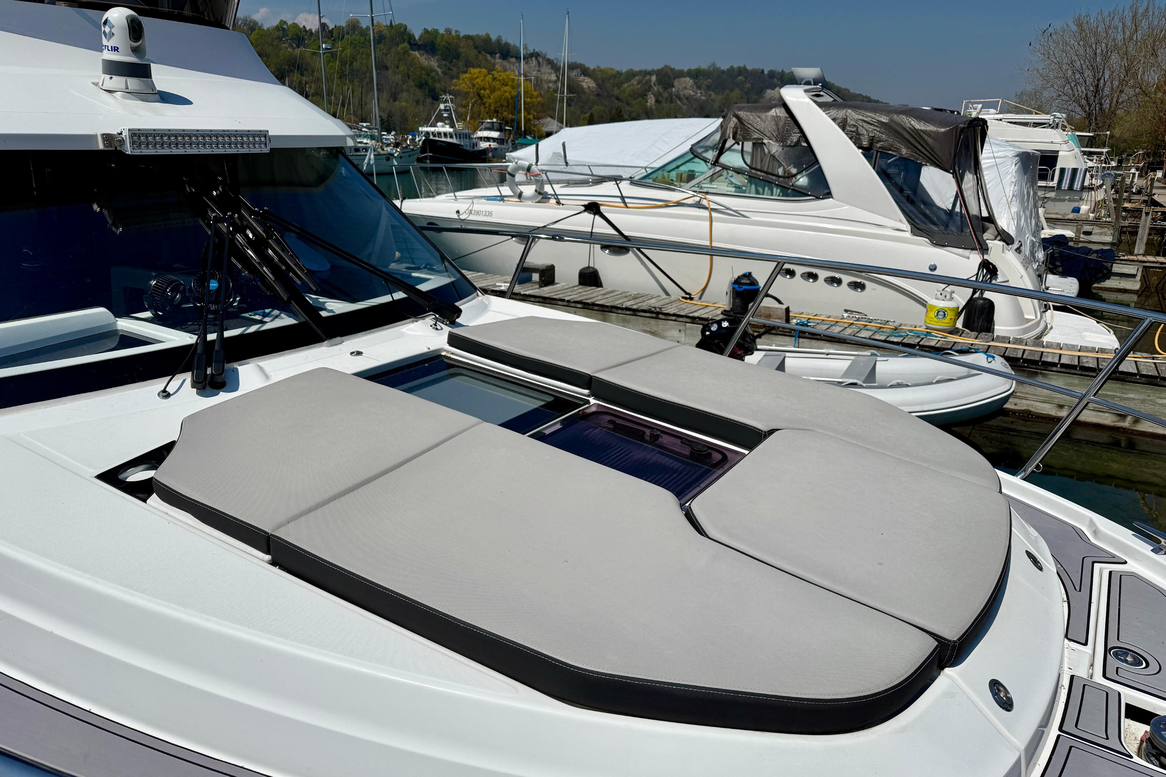 2022 Jeanneau NC 1095 Fly yacht with sunbathing deck, docked at marina.