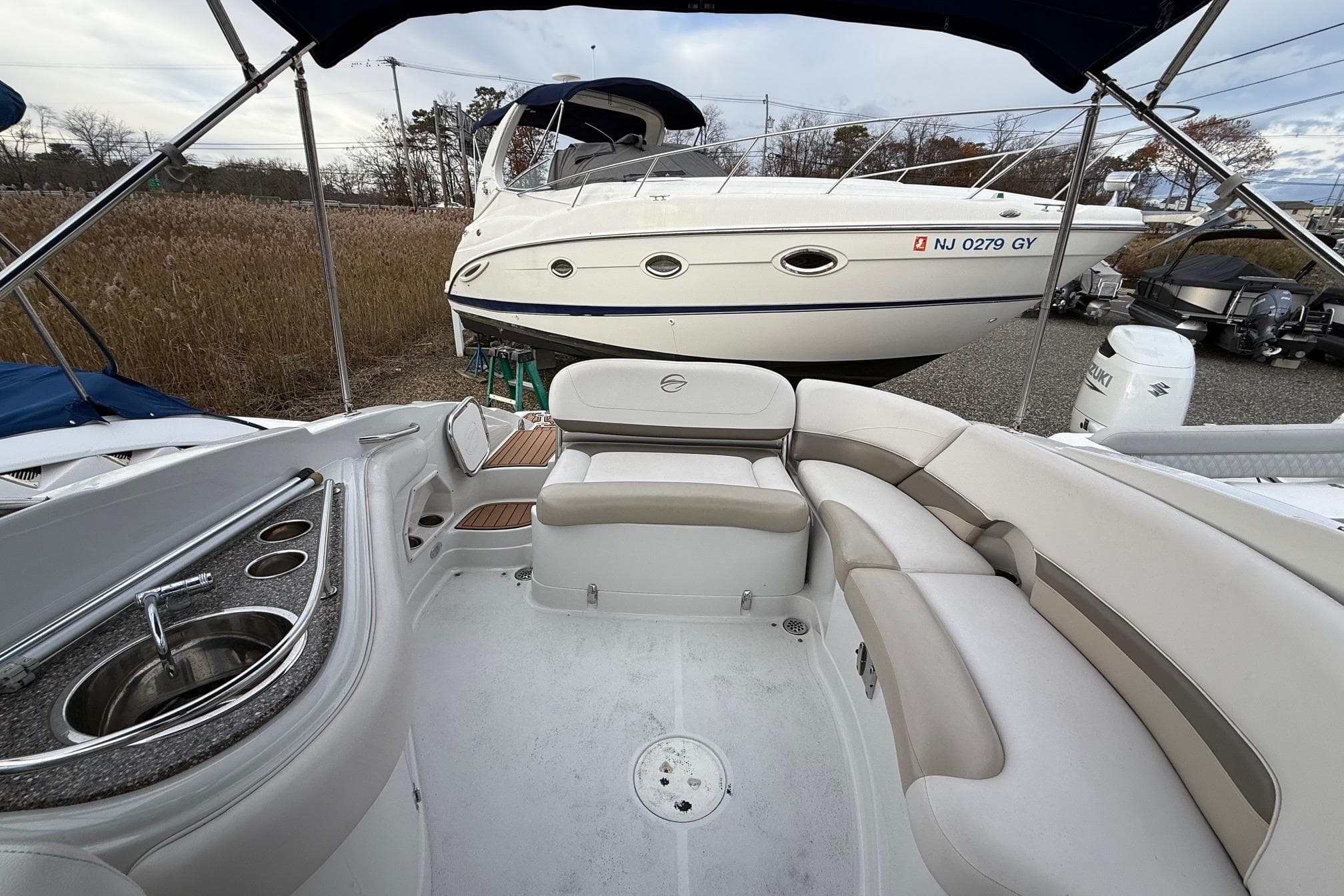 2013 Crownline Eclipse E6 boat interior with seating and sink, docked near another boat.