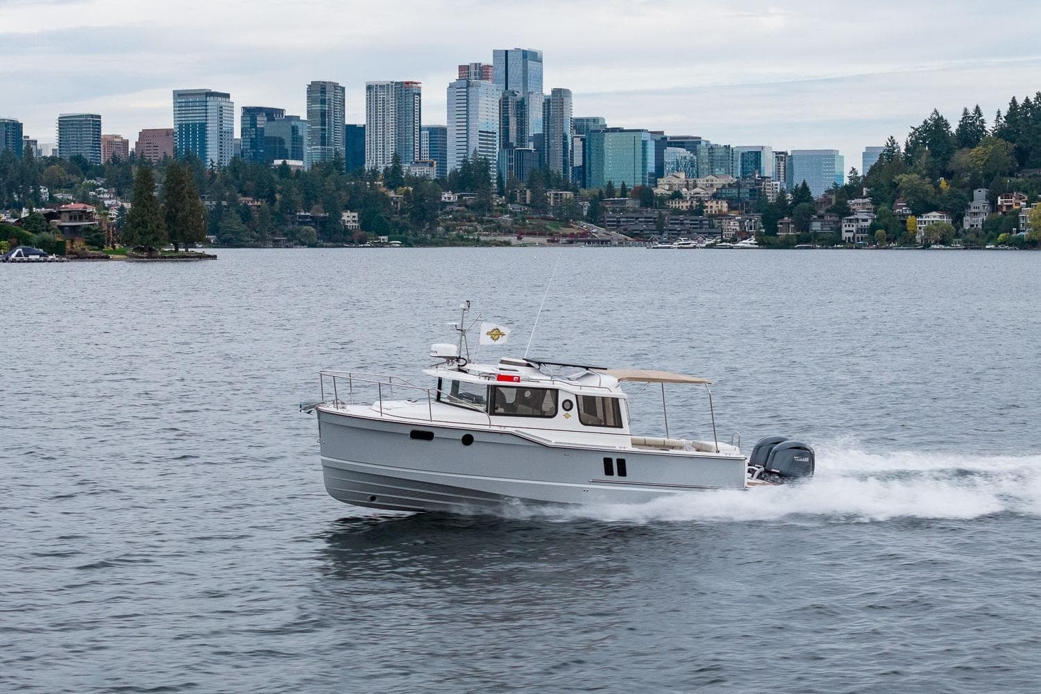 2026 Ranger Tugs R-27 cruising on a lake with city skyline in background.
