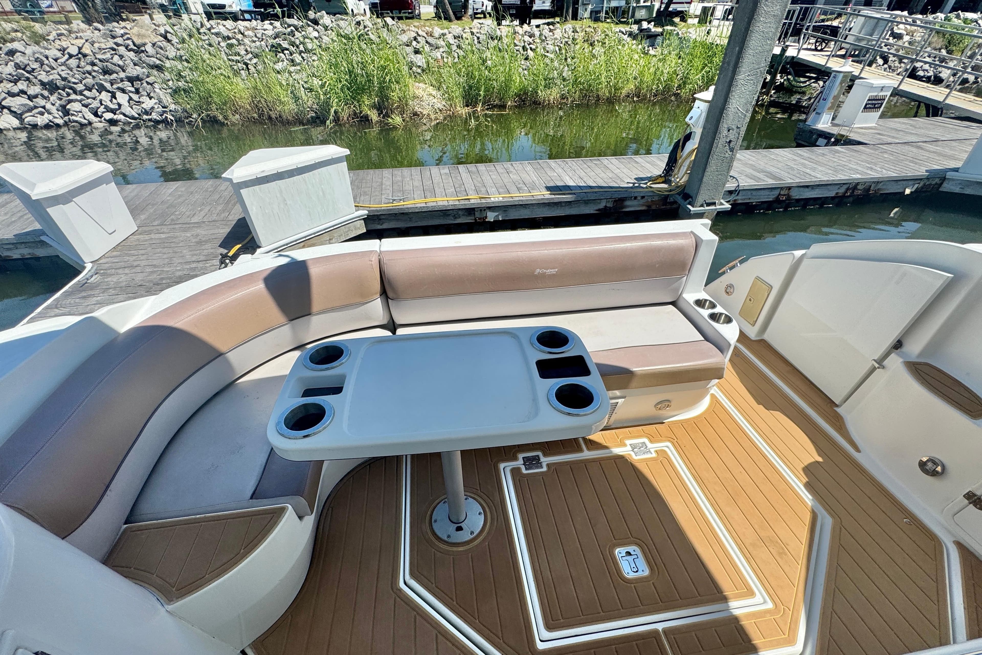 2008 Cruisers 420 boat interior with seating and table, docked by the water.
