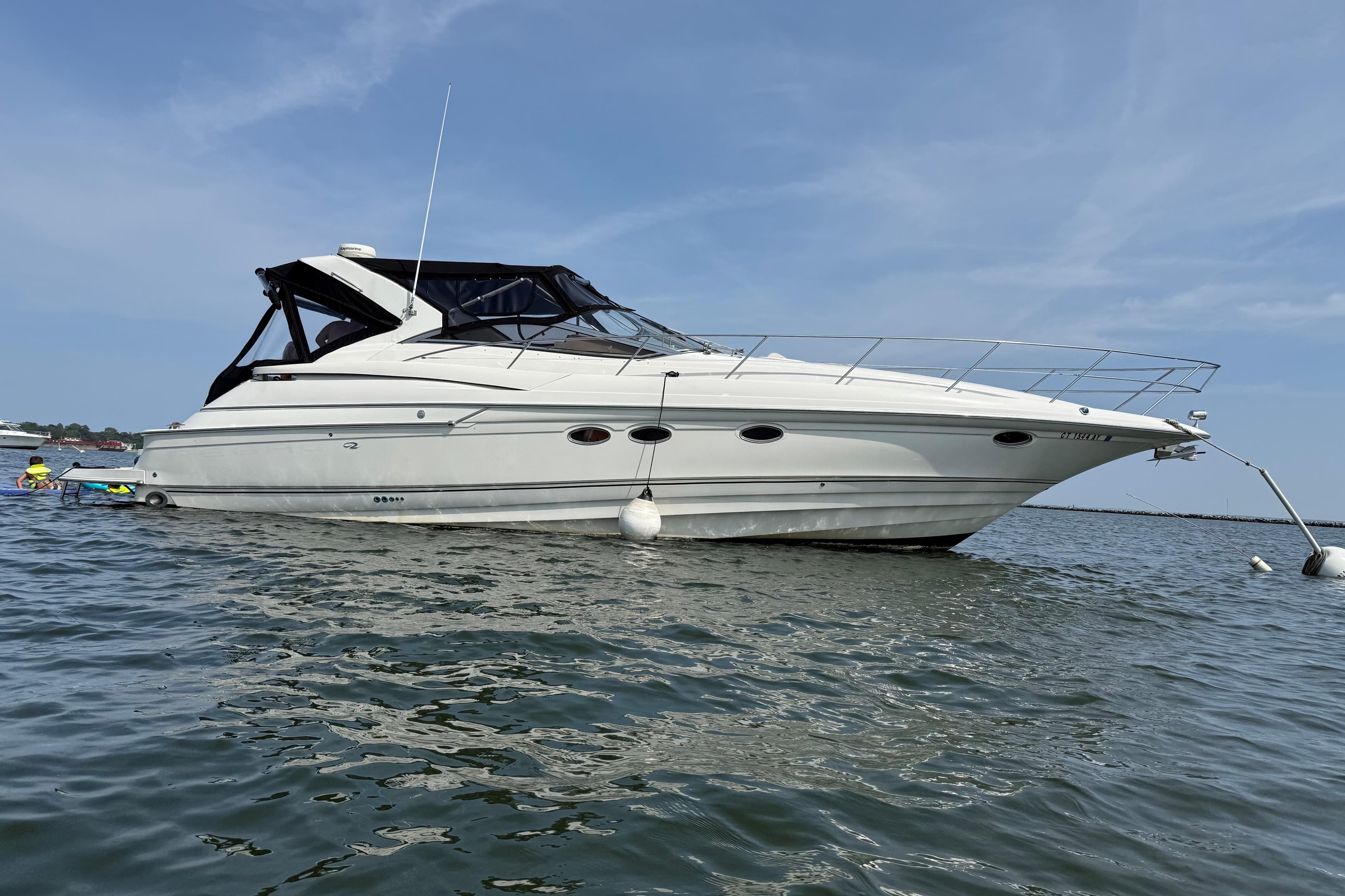 2001 Regal Commodore 4160 yacht anchored on calm water under a clear blue sky.