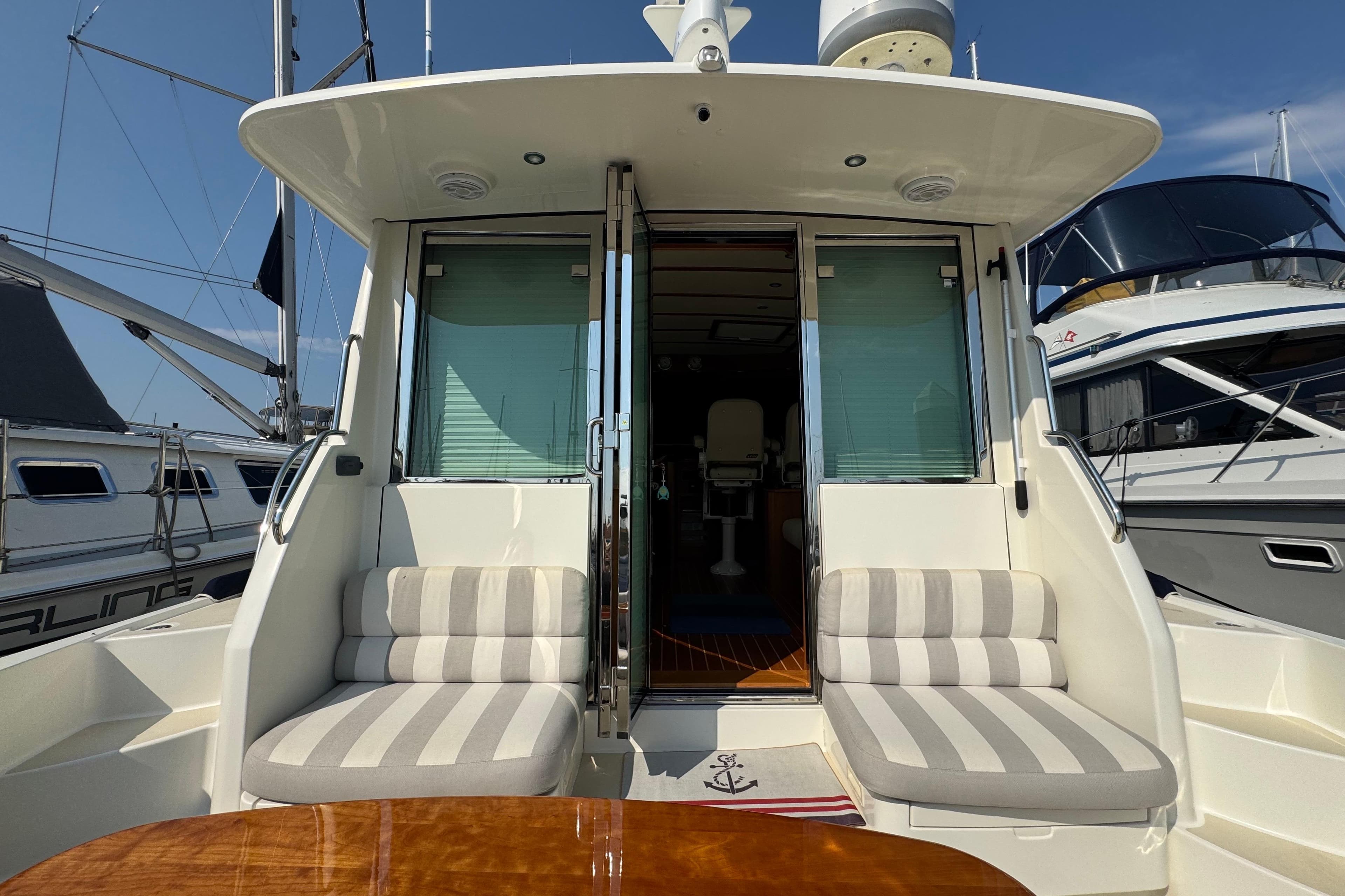 2016 Sabre Craft Salon Express yacht with striped seating and open cabin doors.