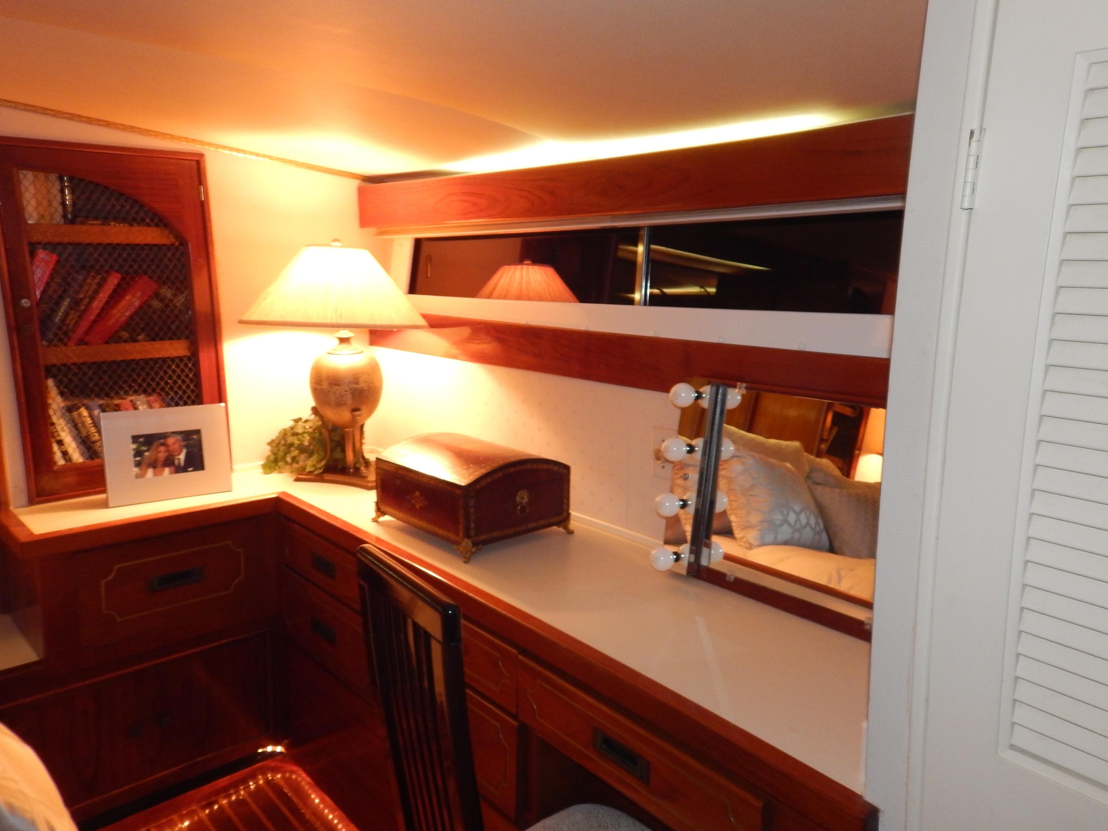 1974 Pacemaker Cockpit Motoryacht interior with wooden desk, lamp, and mirror.