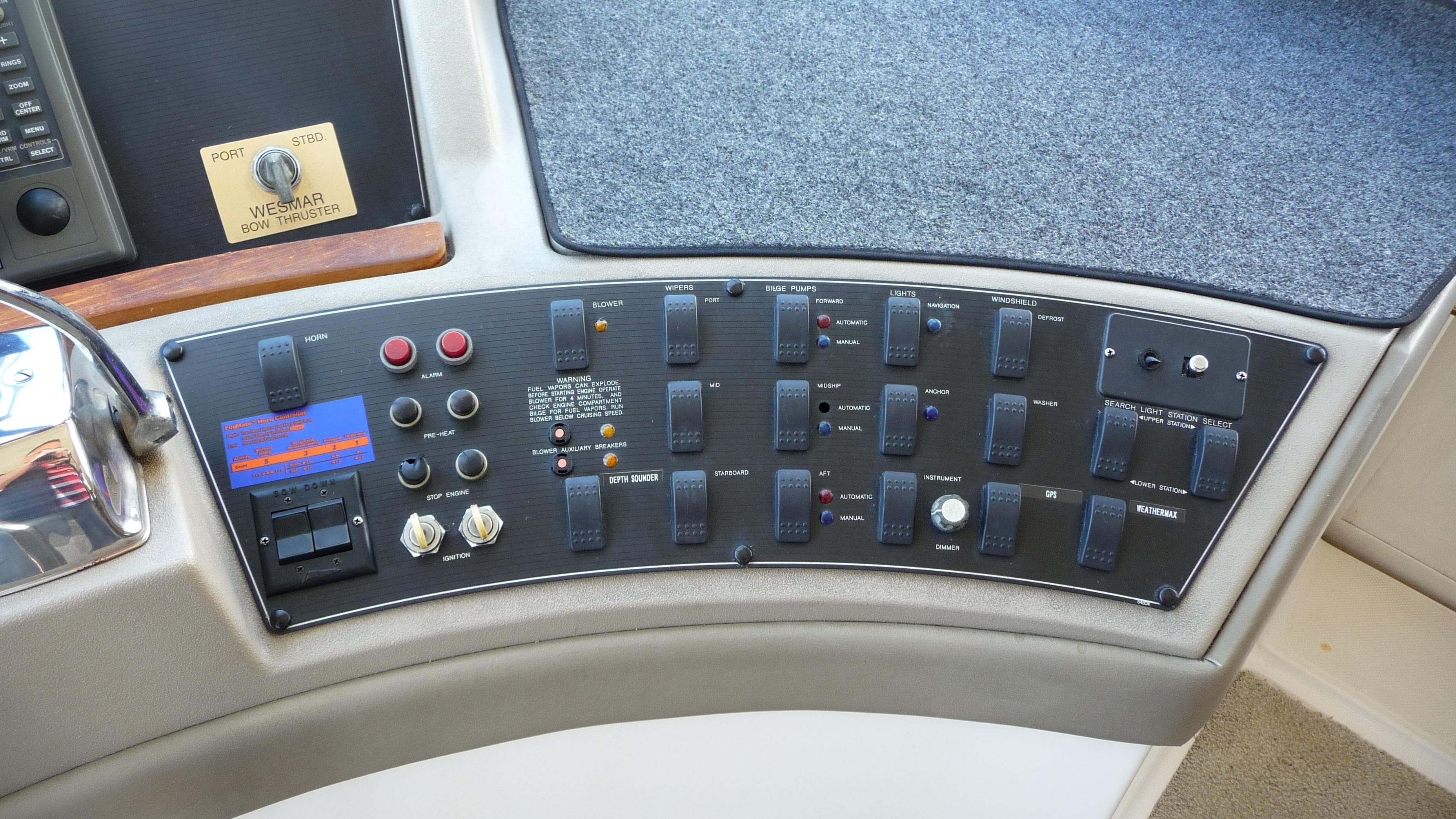 Control panel of a 1995 Bayliner 4788 Pilot House Motoryacht with various switches and buttons.