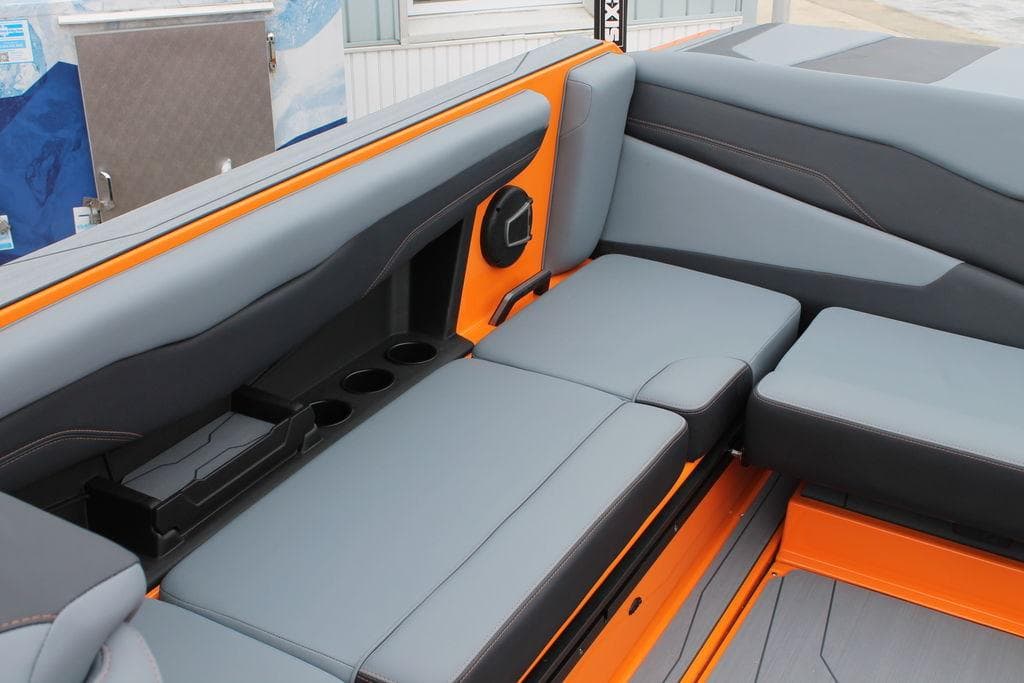2024 Axis T235 boat interior with gray and orange seating, cup holders, and speaker.