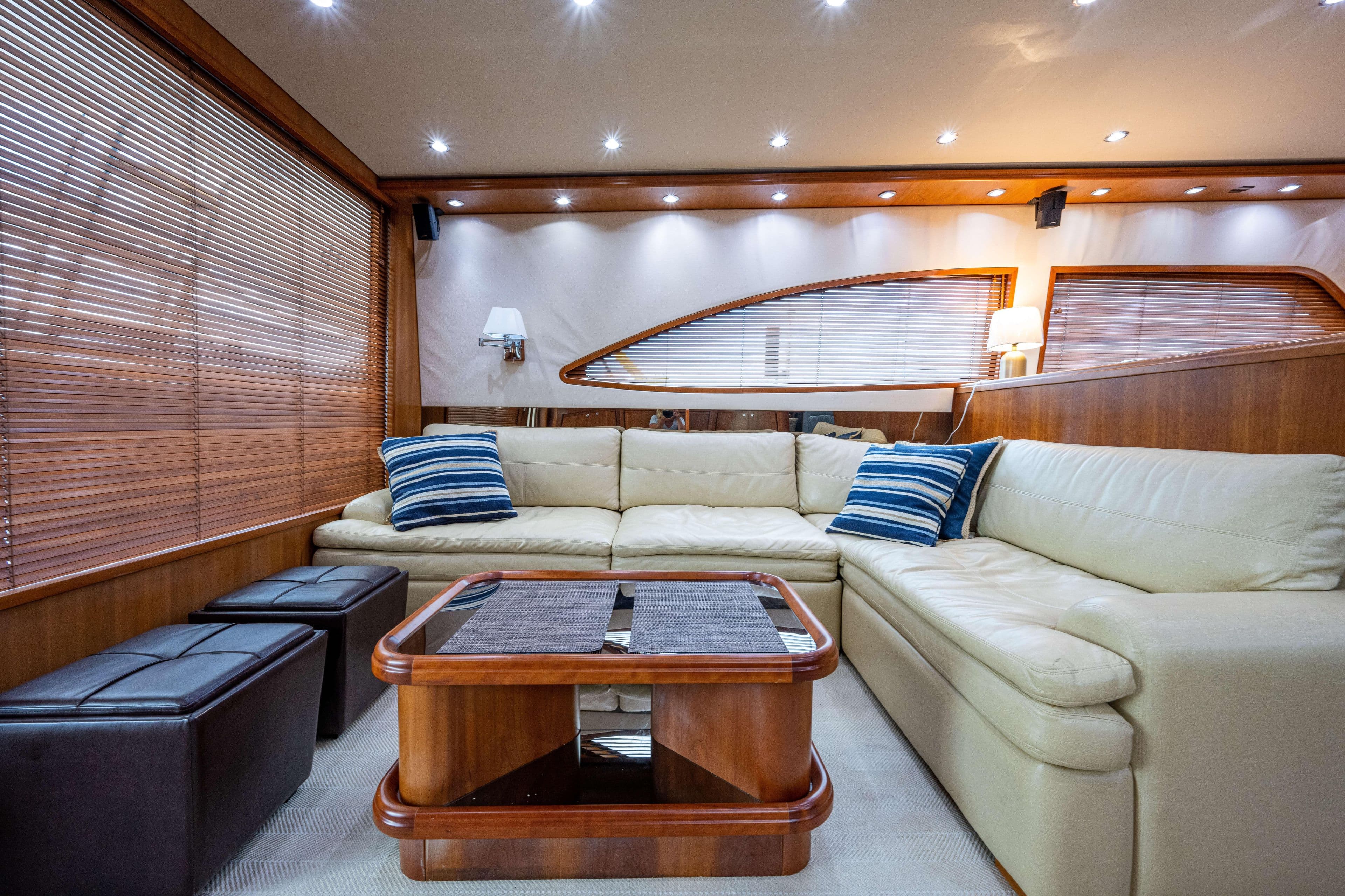 Luxurious interior of 2008 Bertram 570 yacht with cream sofa and wooden accents.