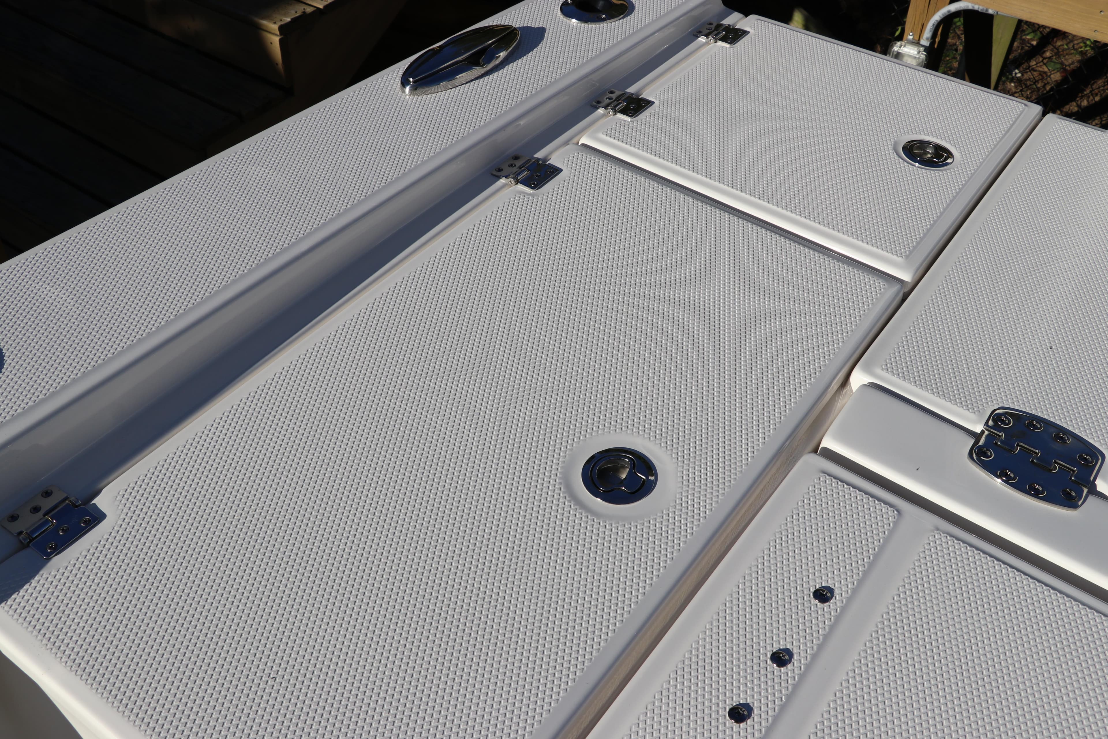 2024 Robalo 266 Cayman boat deck with textured surface and storage compartments.