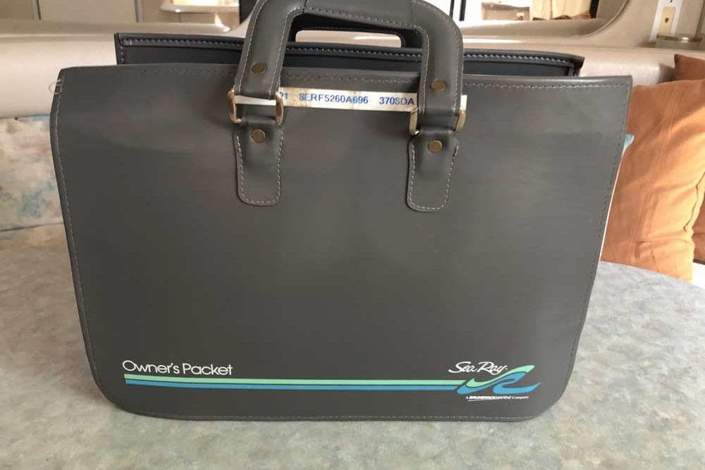 Owner's packet for 1996 Sea Ray Sundancer 370, displayed on a table.