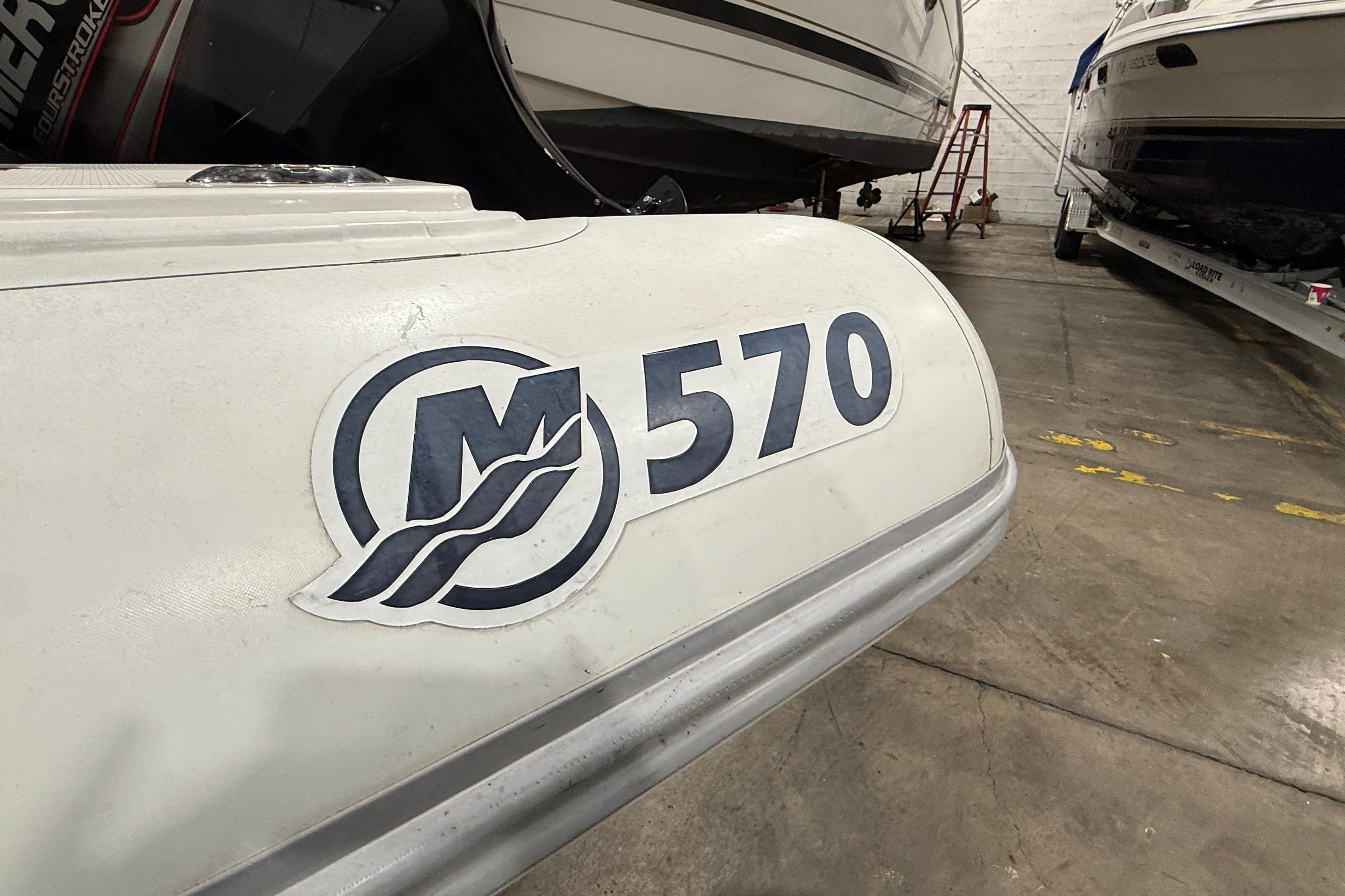 White Mercury 570 boat in a warehouse, showcasing logo and model number.