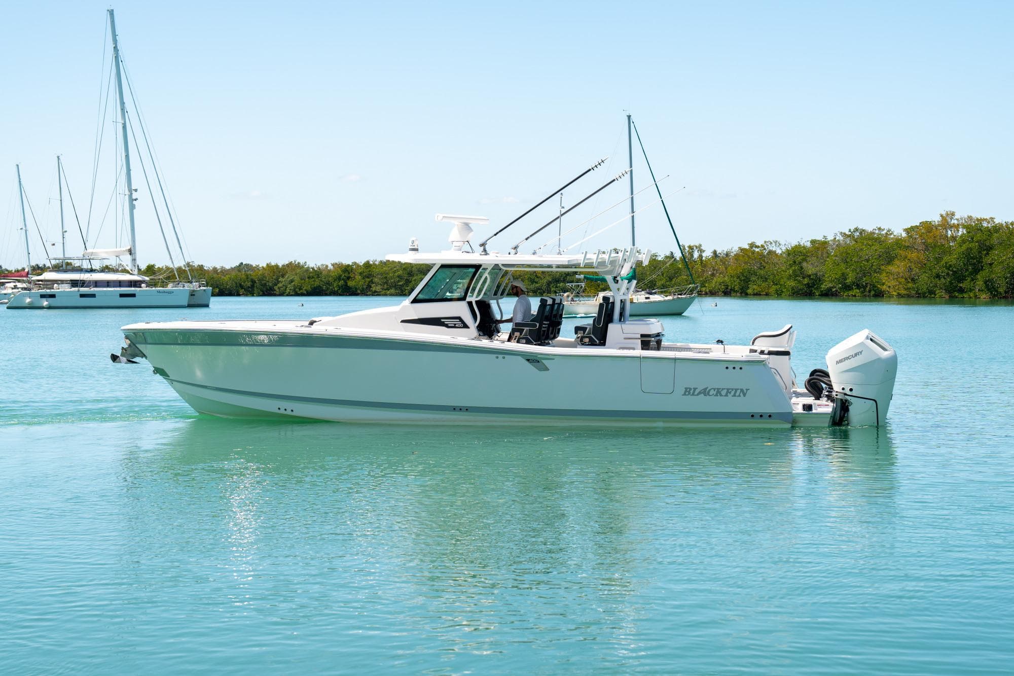 2024 Blackfin 400CC boat on calm water, surrounded by sailboats and greenery.