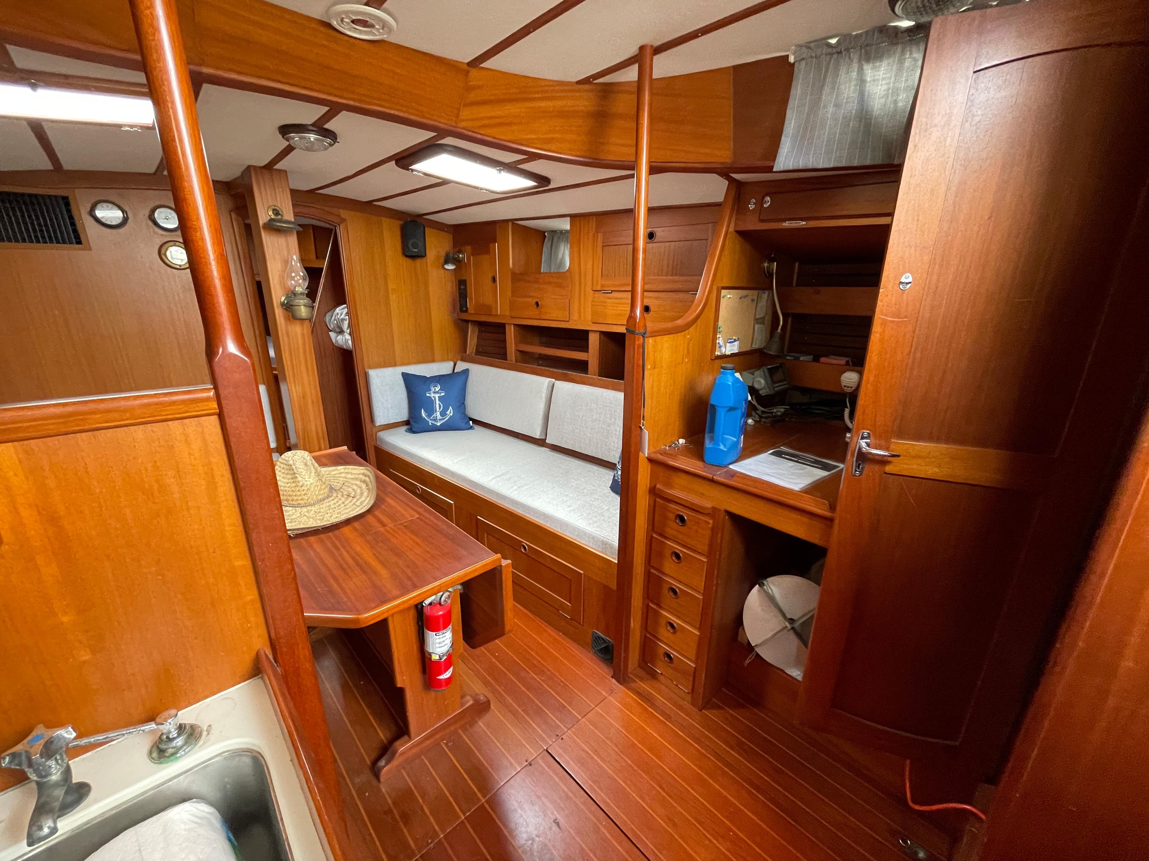 Interior of 1983 Najad 371 American CC sailboat with wooden furnishings and cozy seating.
