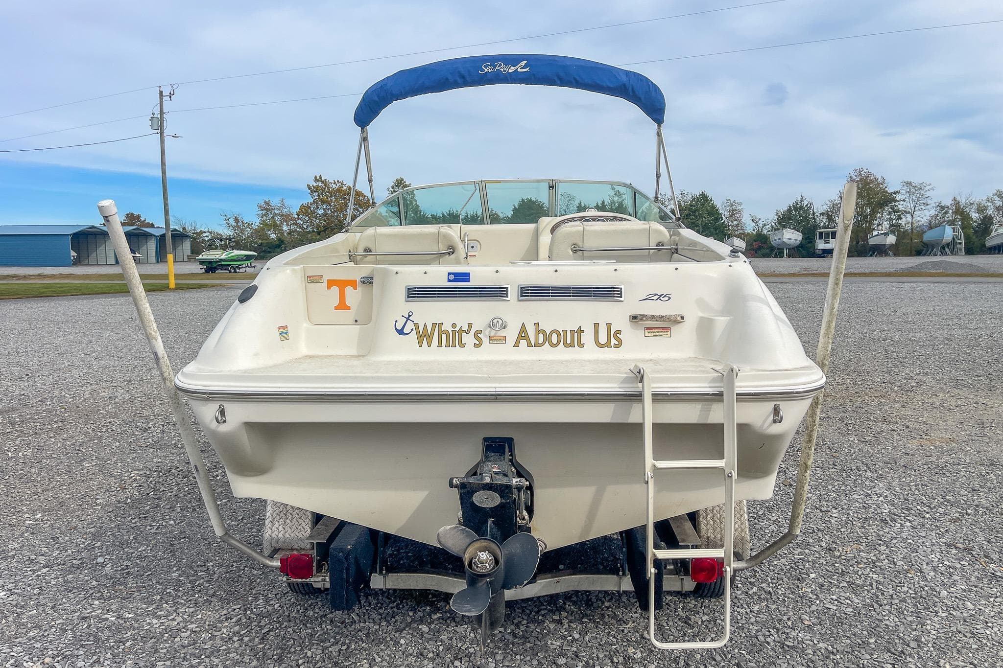 1999 Sea Ray 215 Express Cruiser boat with custom name "Whit's About Us" on the stern.