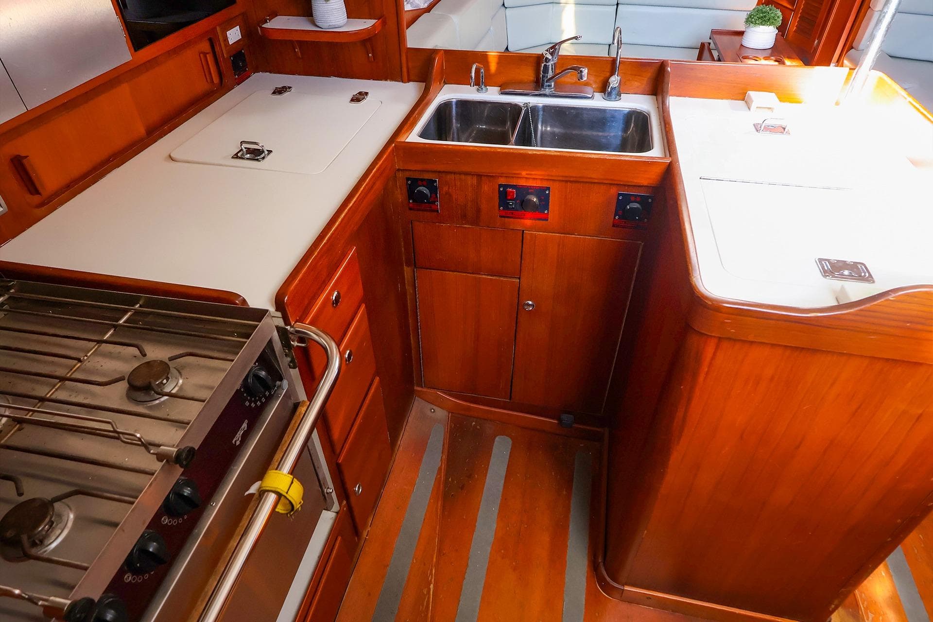 2004 J Boats J/46 yacht kitchen with wooden cabinetry, stove, and double sink.