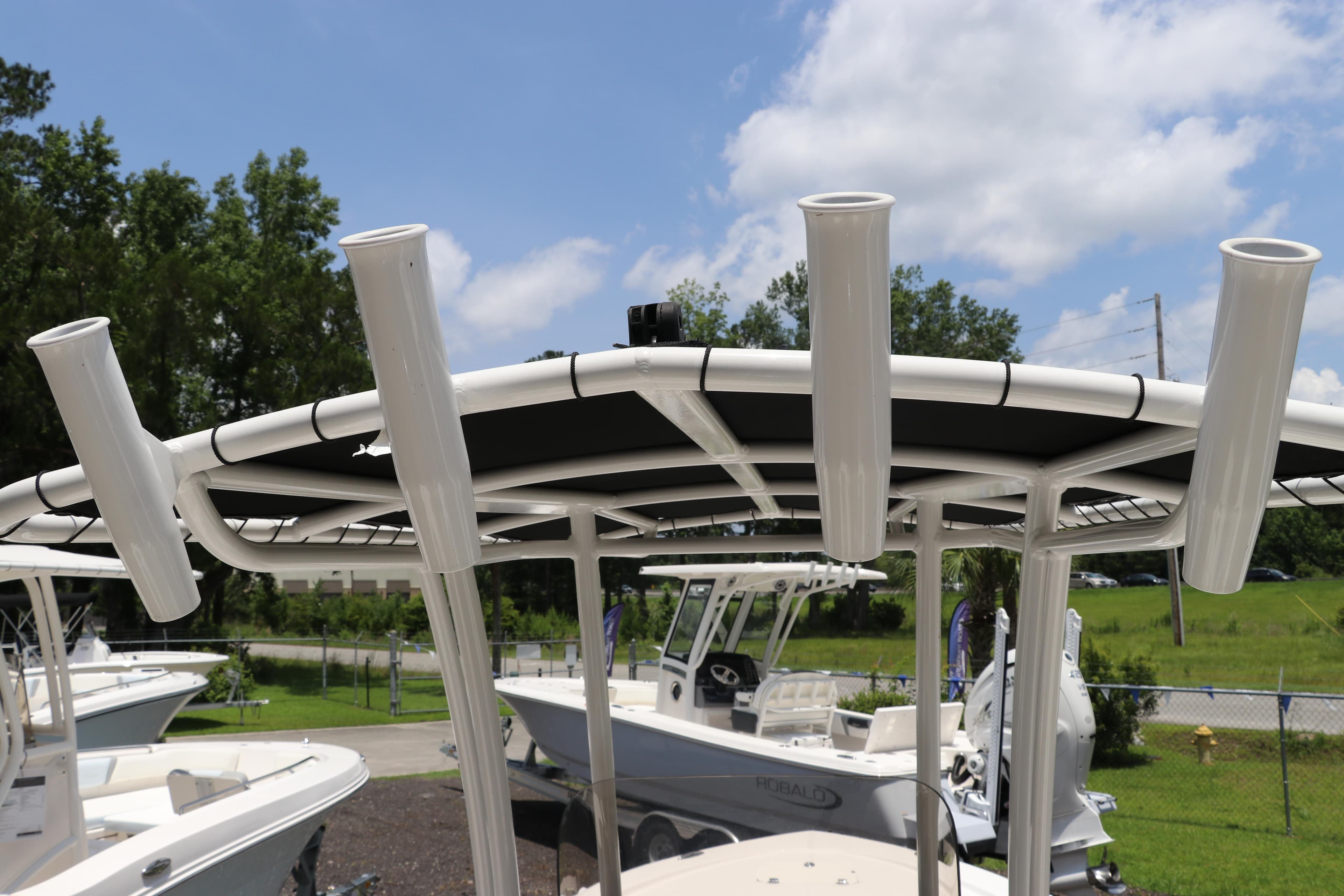 2025 Robalo 206 Cayman boat with rod holders and canopy, parked outdoors.
