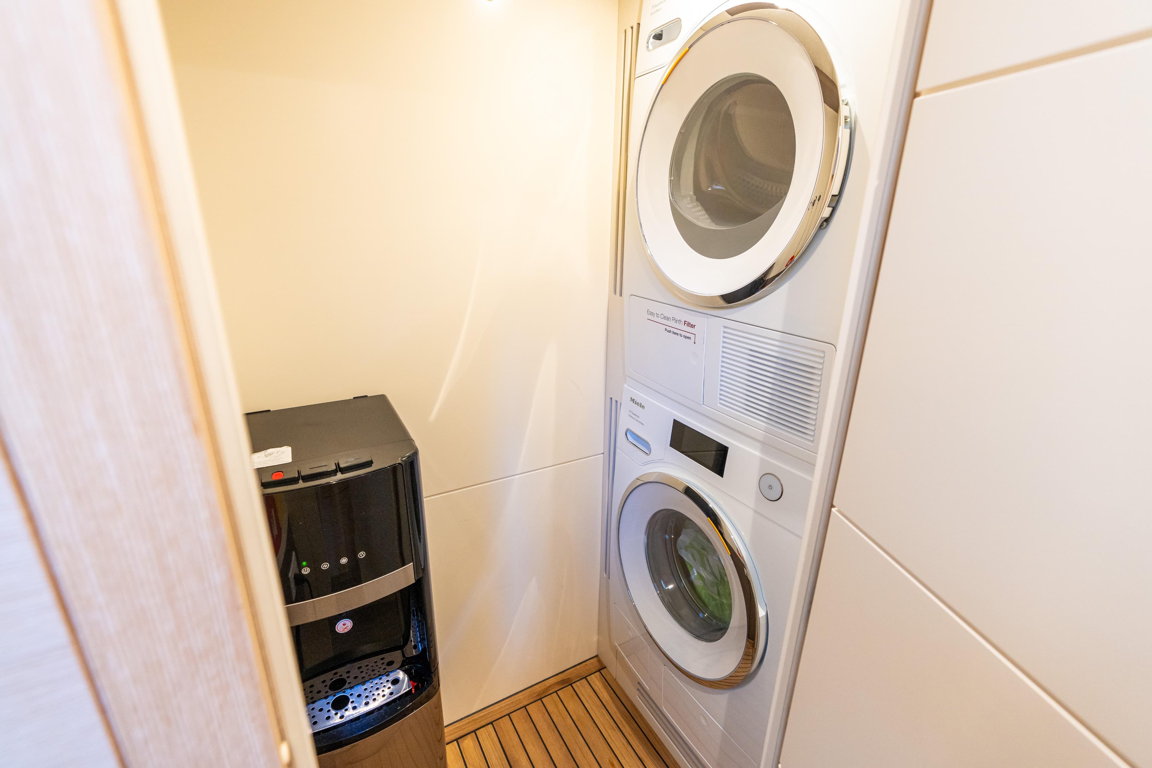 Laundry area in 2019 Sirena 64 yacht with washer, dryer, and water dispenser.