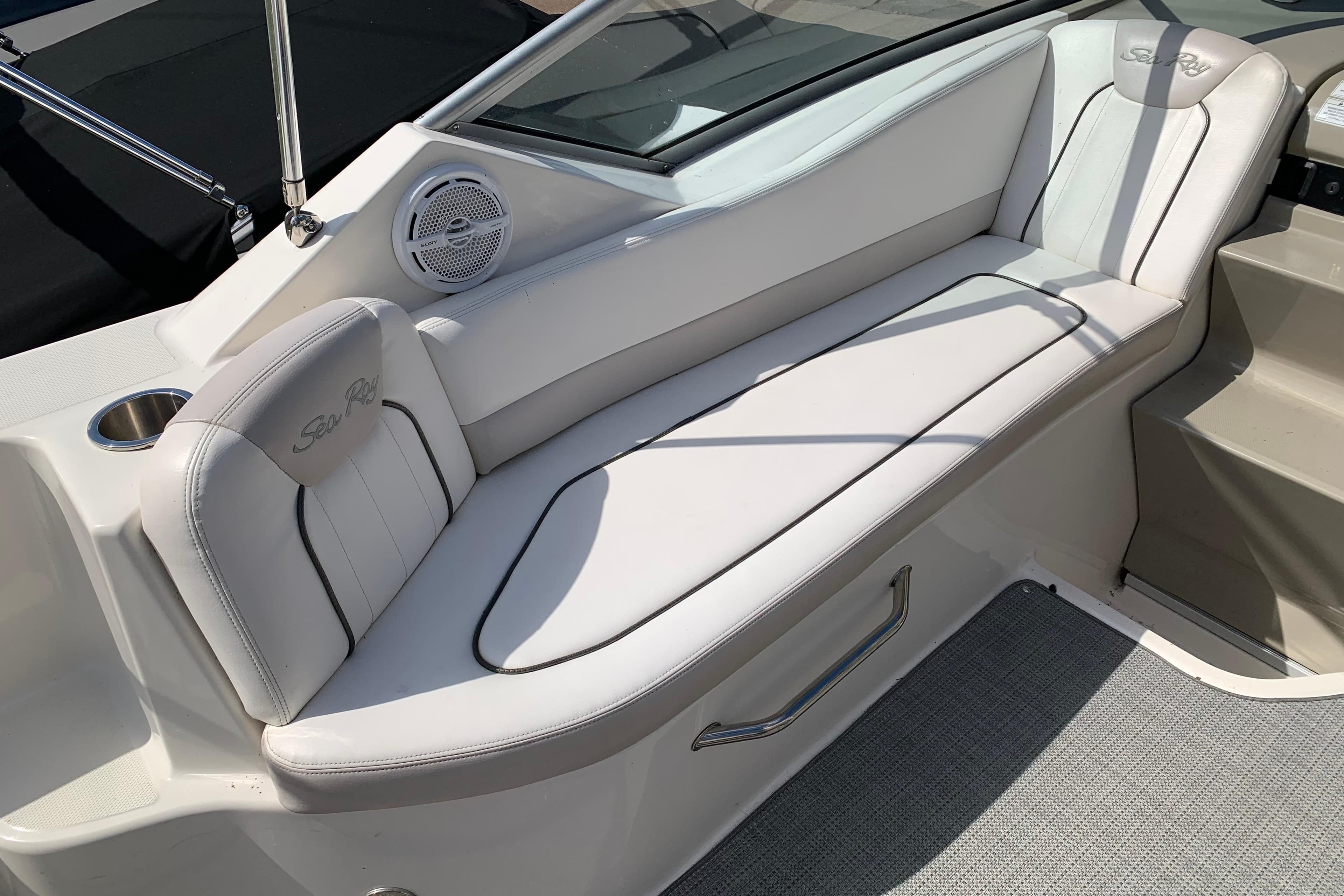 Luxurious seating on a 2012 Sea Ray 240 Sundancer boat, featuring white upholstery and speaker.