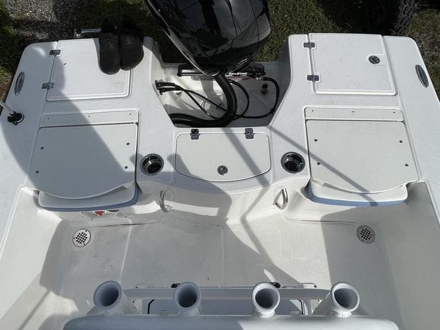 2024 Robalo 206 Cayman boat deck with storage compartments and rod holders.