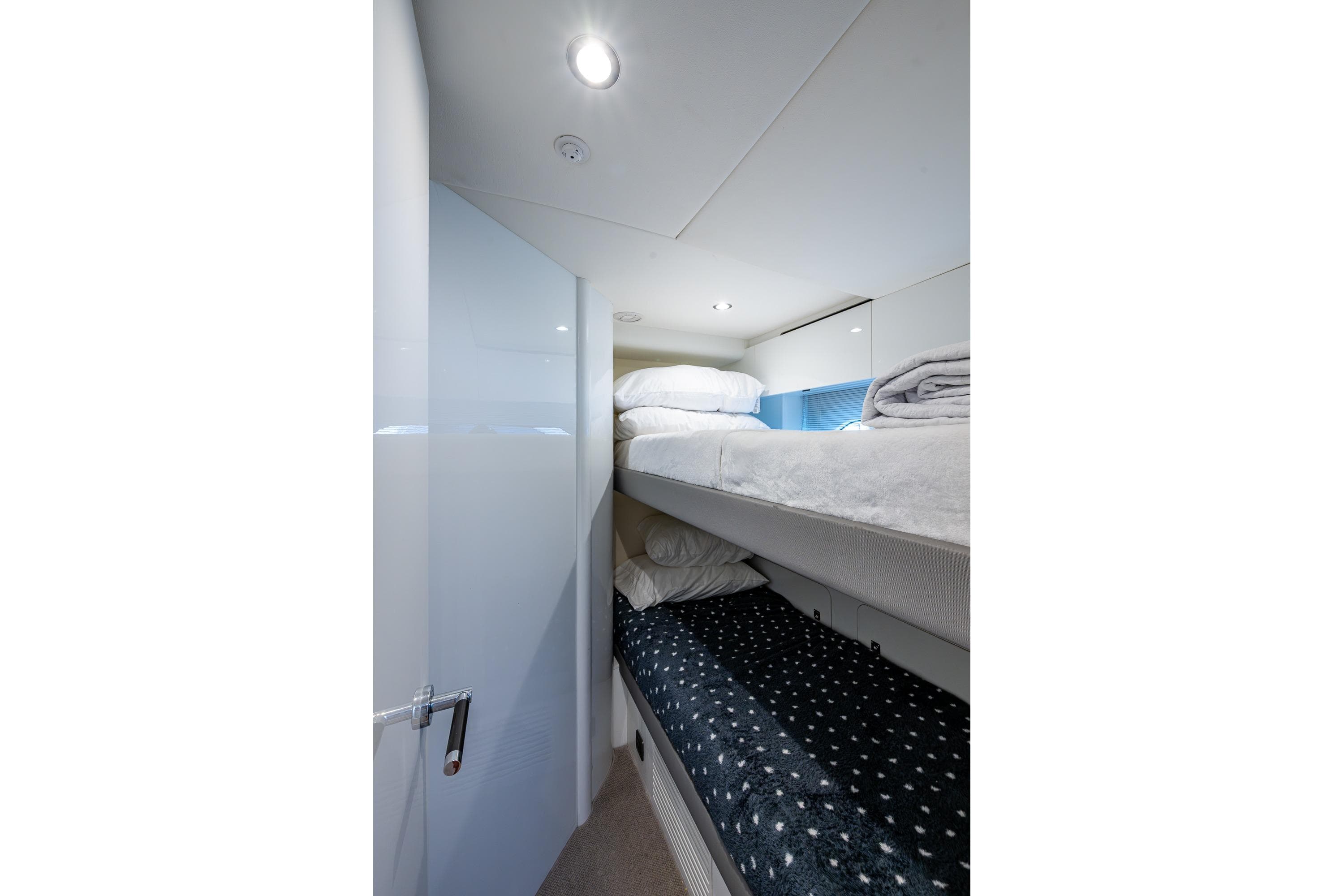 2022 Princess X95 yacht interior with cozy bunk beds and modern lighting.