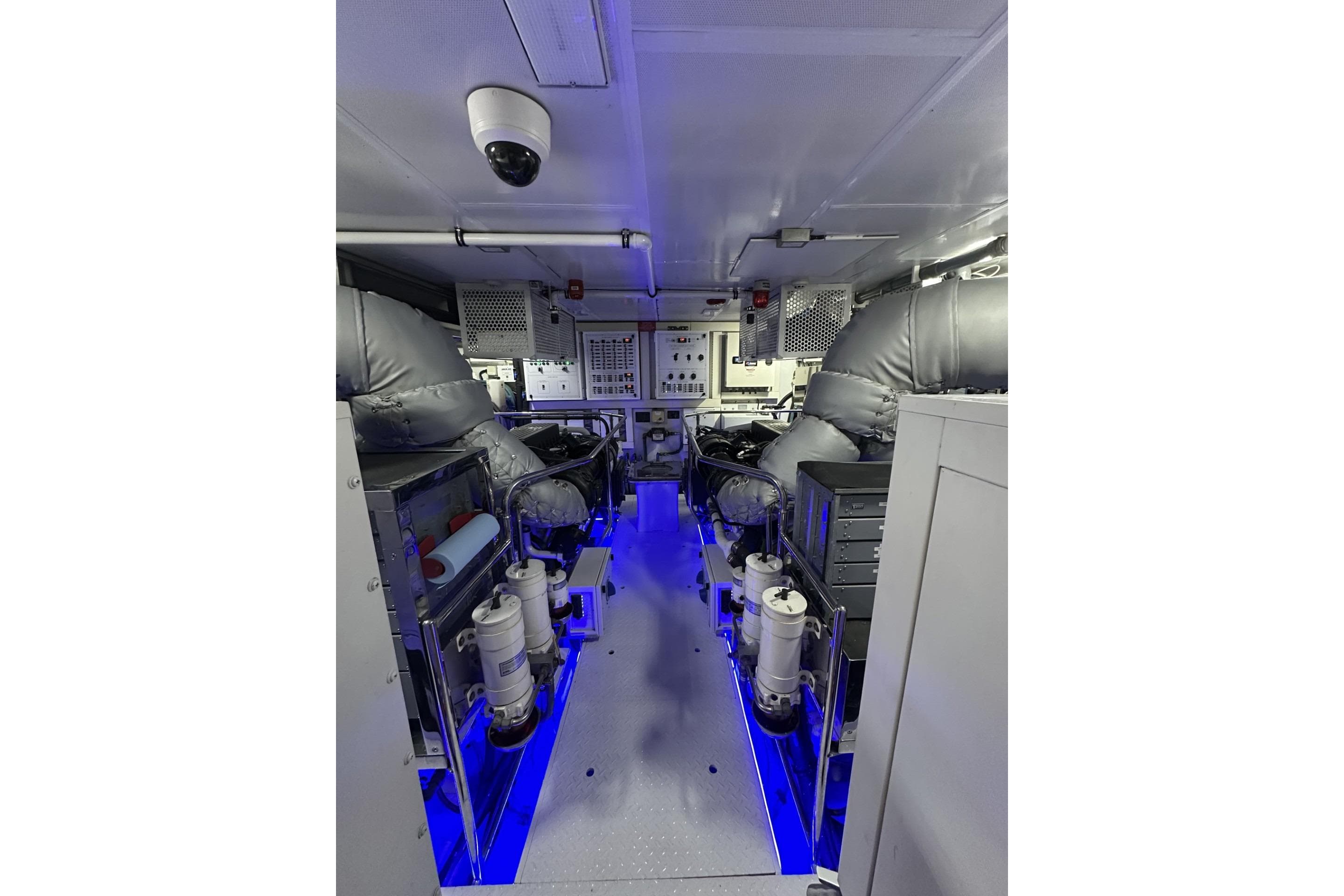 Engine room of 2014 Hargrave Sky Lounge yacht with illuminated machinery and control panels.