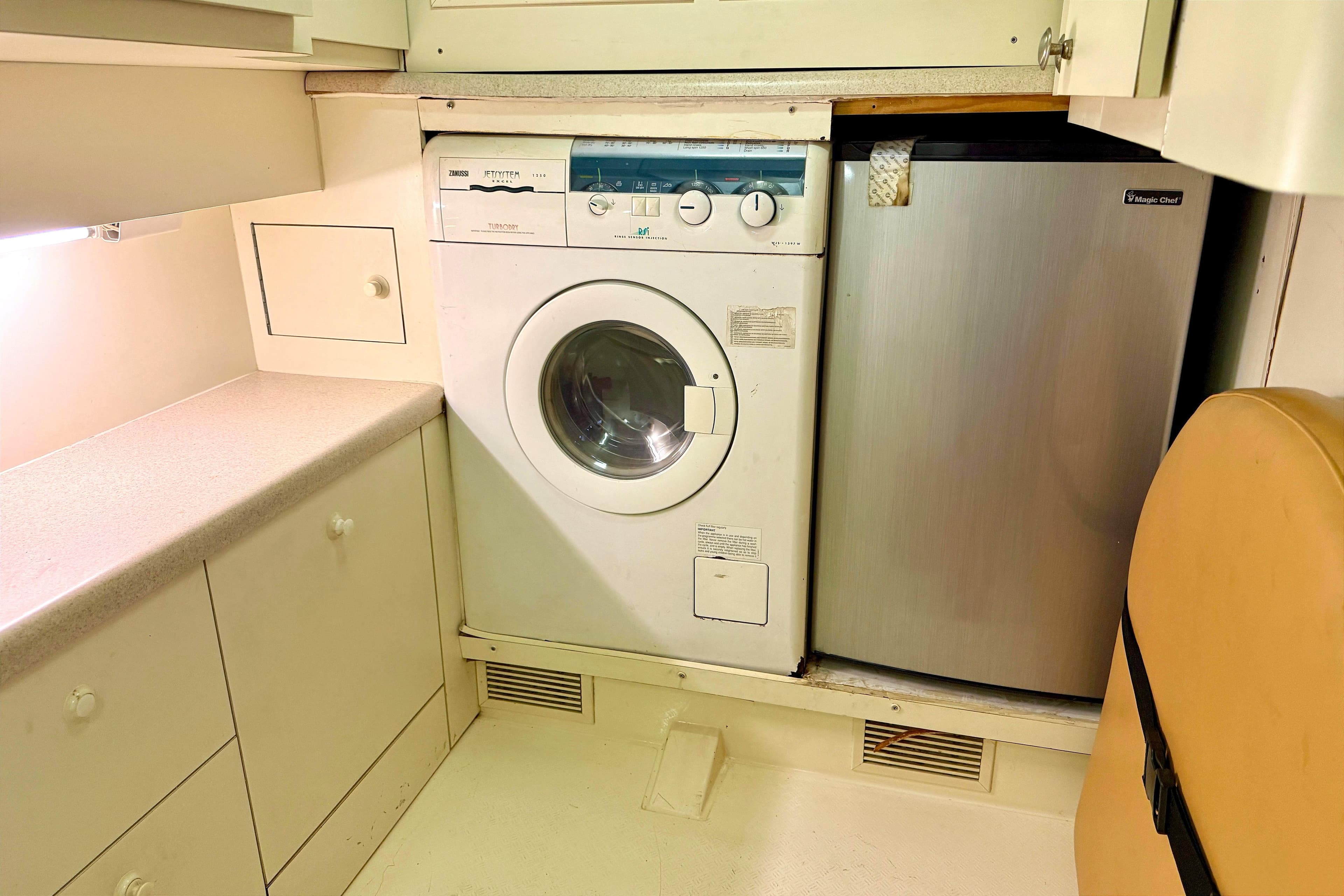 Laundry area in 2000 Fairline Squadron 55 yacht with washer and mini fridge.