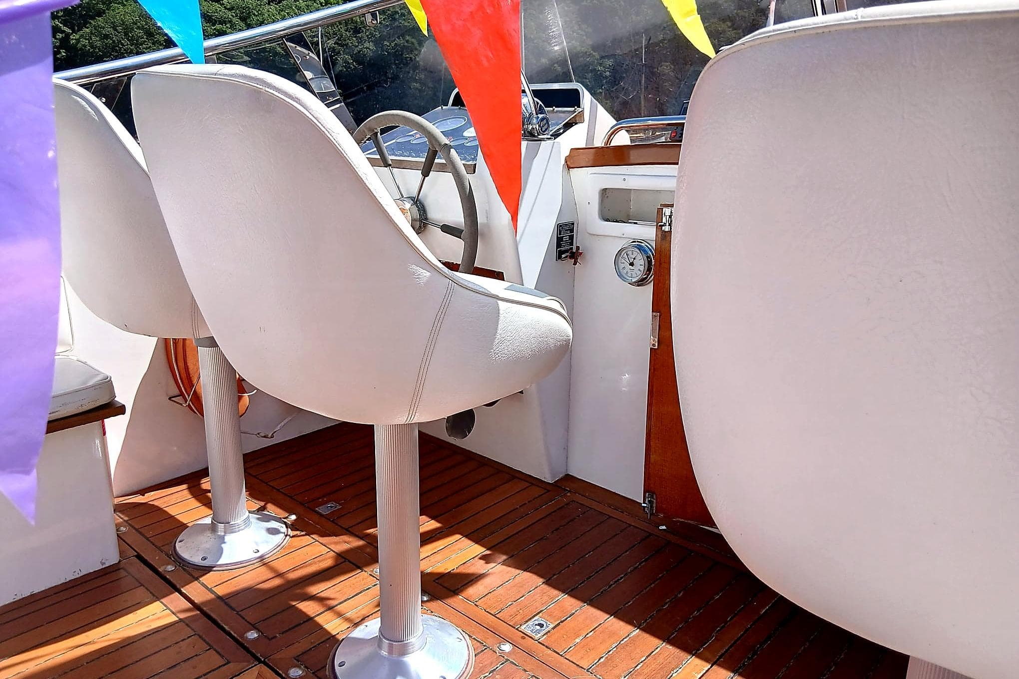Interior of 1973 Fairey Super Swordsman 33 boat with white seats and colorful flags.