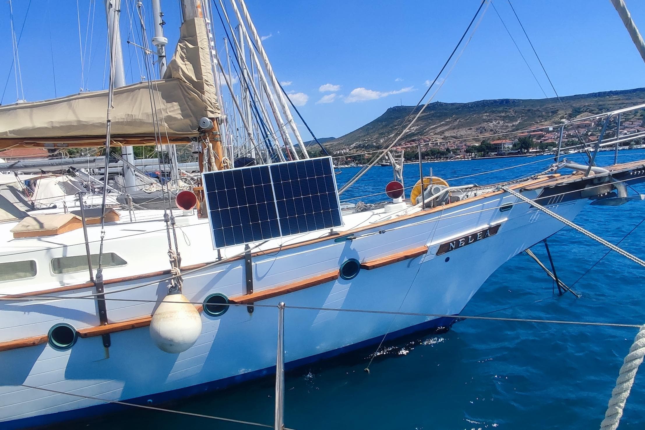 Vintage 1980 Formosa 51 sailboat with solar panel docked in scenic harbor.