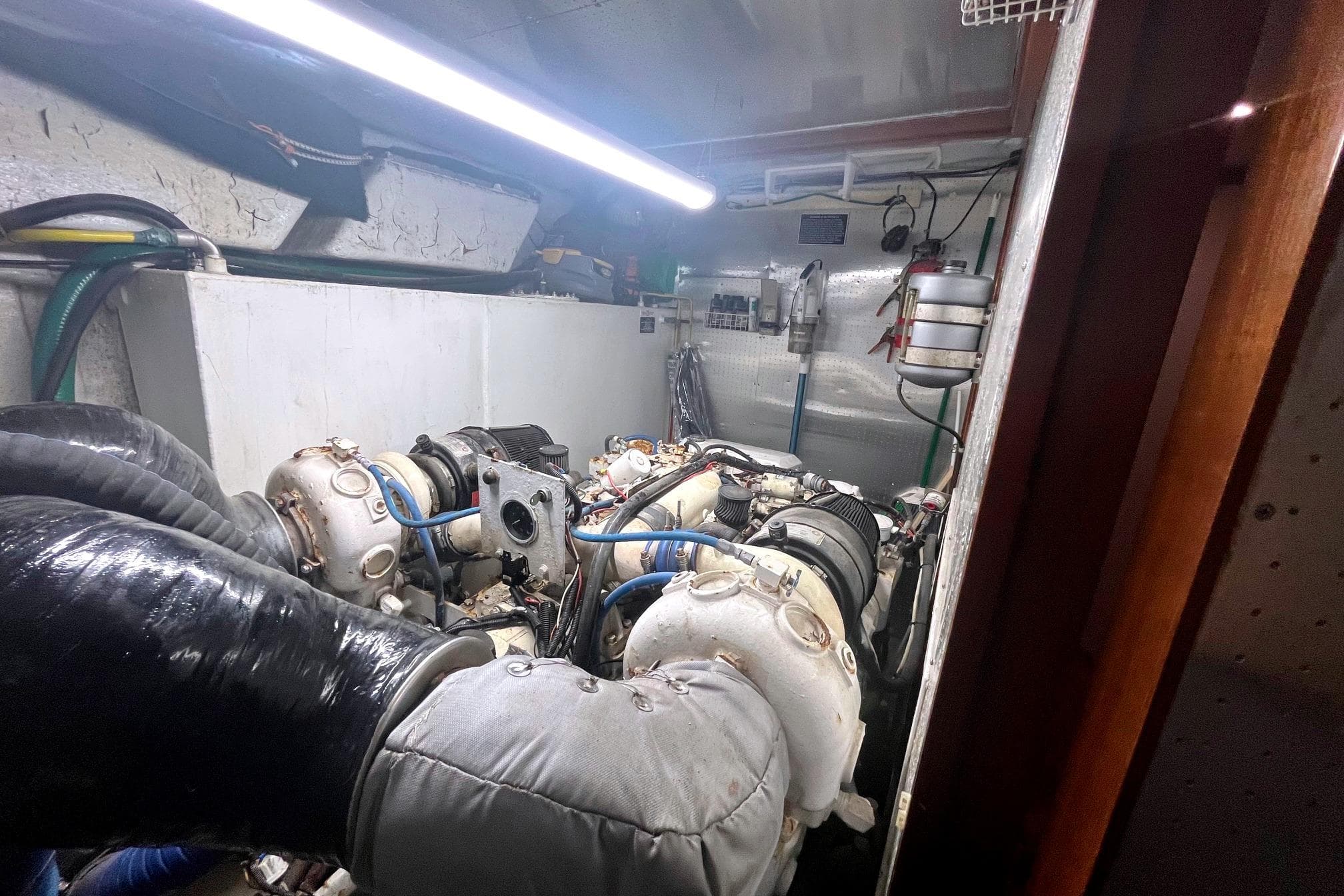 Engine room of a 1999 Jefferson Marquessa 56 yacht, featuring complex machinery and piping.