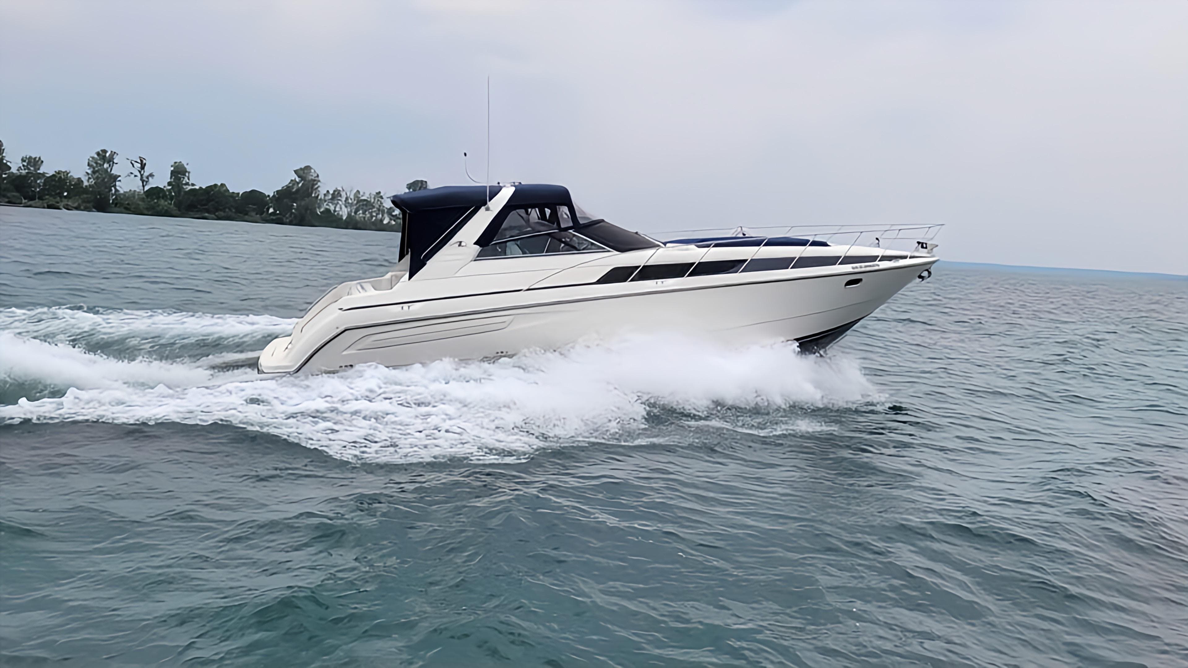 1998 Bayliner 4085 Avanti cruising on open water, creating a wake.