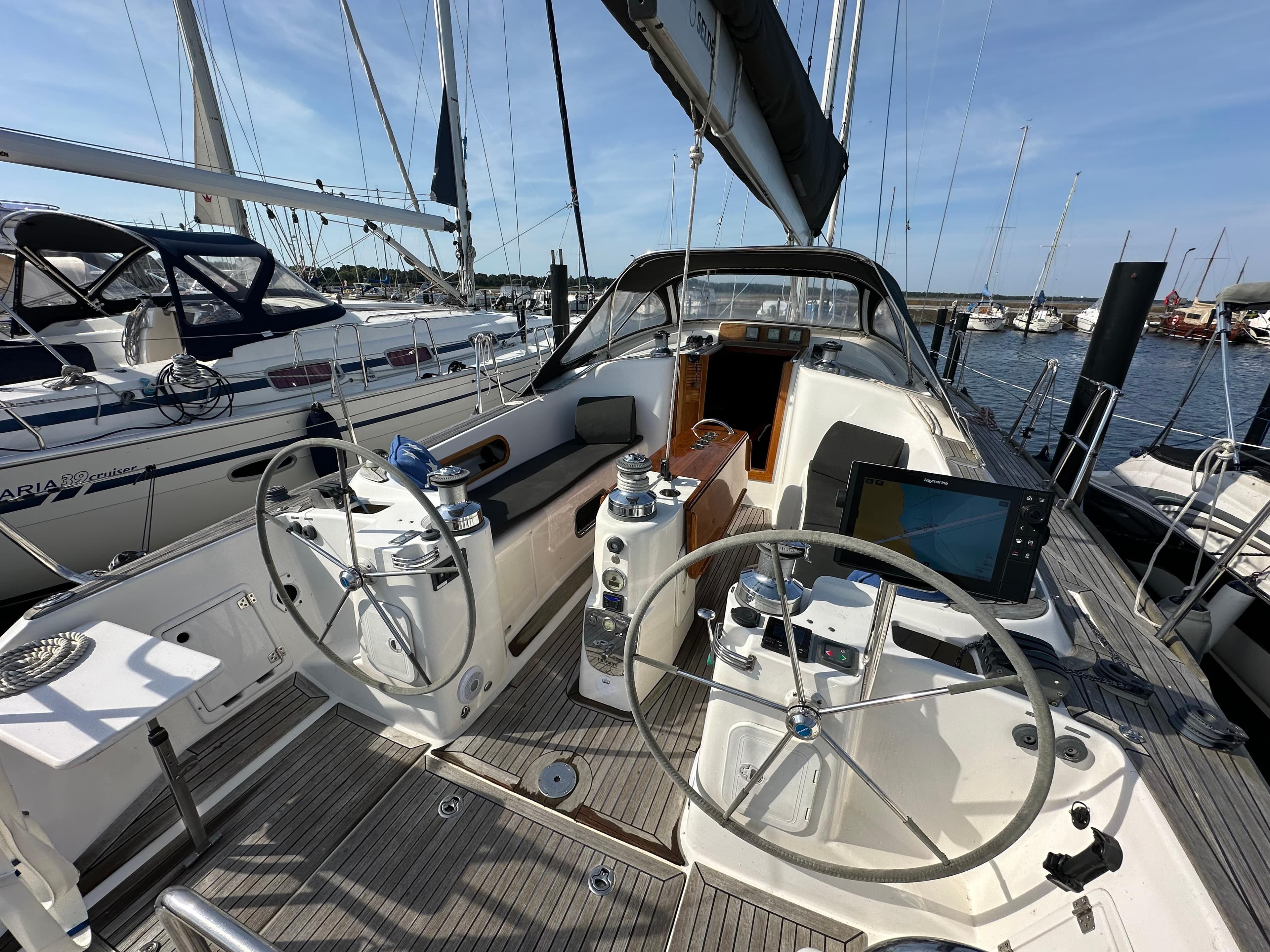 Sailing yacht cockpit with dual steering wheels, Maxi 1300, 2007 model, docked at marina.