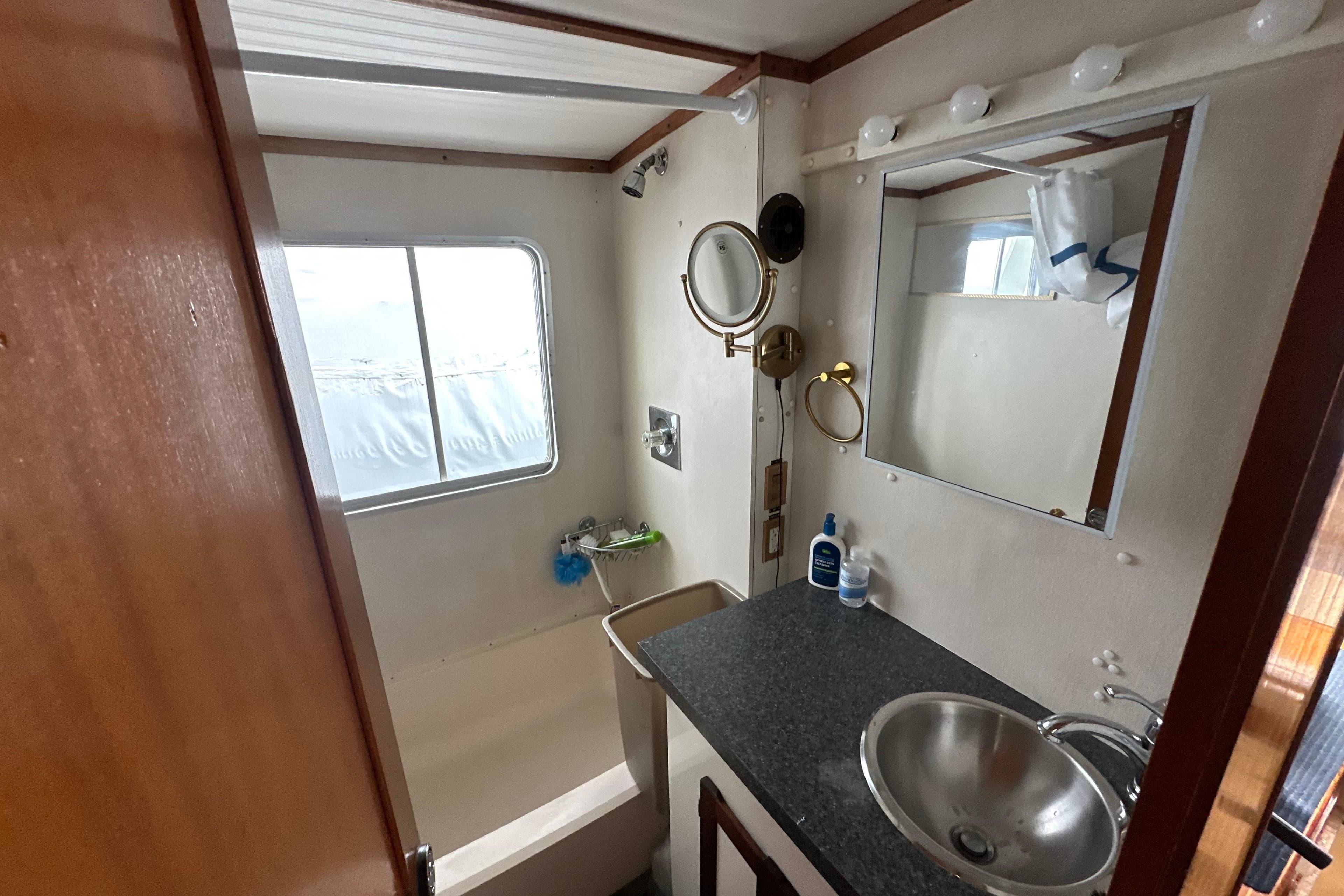 Bathroom interior of 1985 Pearson 43 Trawler with sink, mirror, and window.