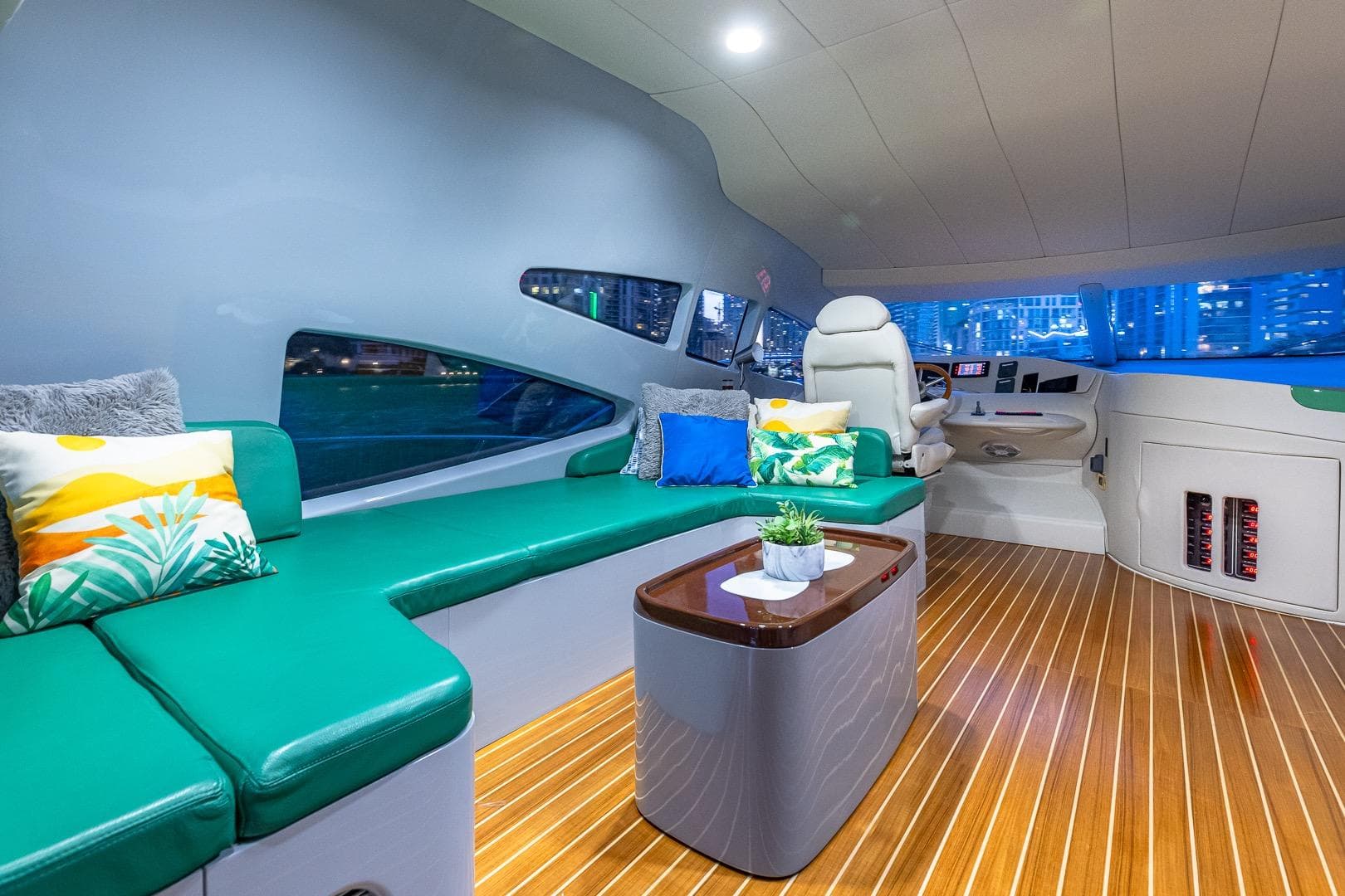 Luxurious interior of 2003 Azimut Fly 68 yacht with green seating and modern helm.
