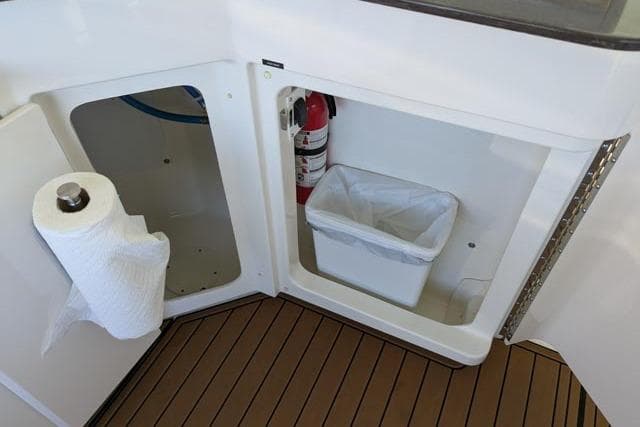 2013 Sea Ray 470 Sundancer yacht interior with trash bin, fire extinguisher, and paper towel holder.