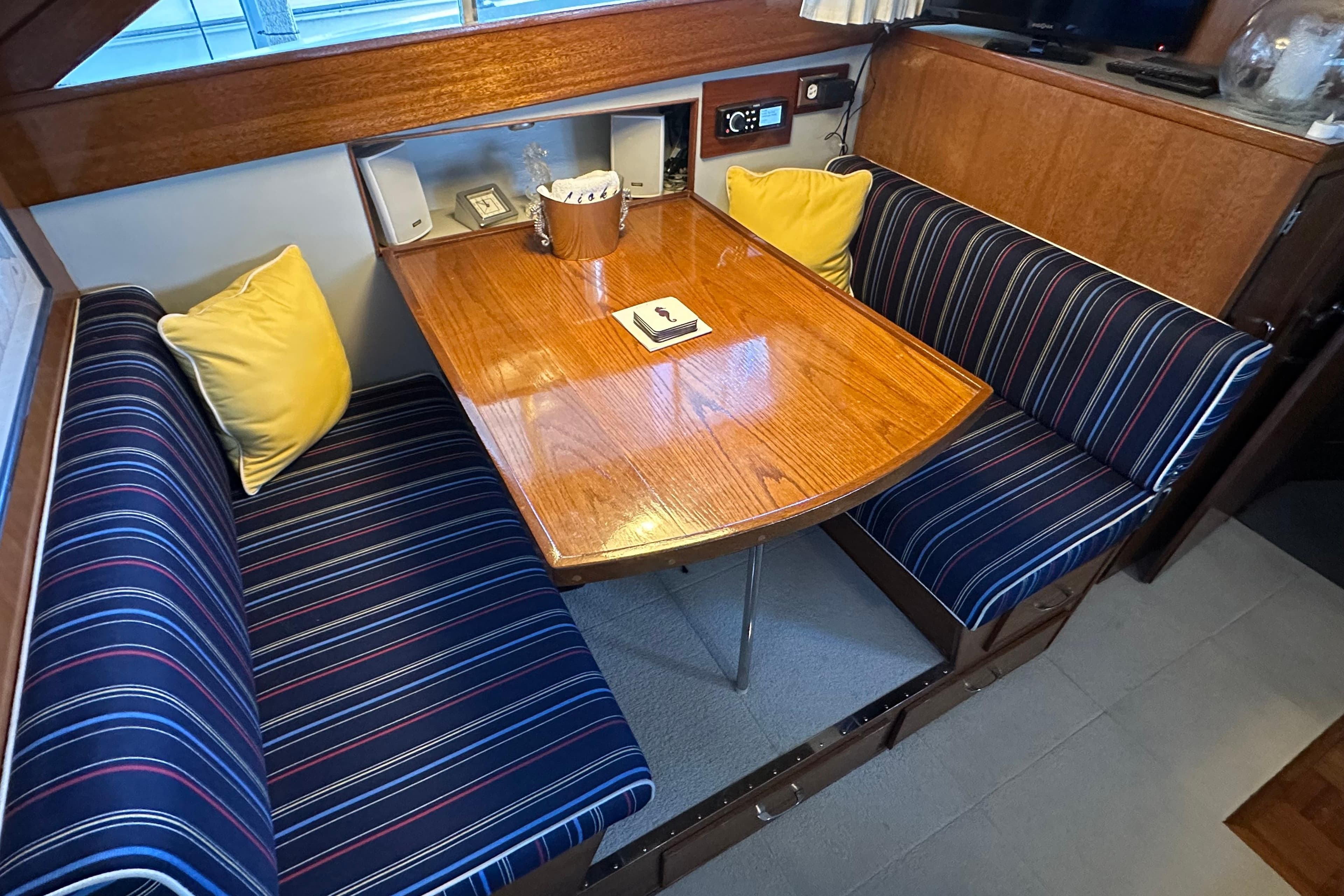 1968 Chris-Craft 35 Commander interior with striped seating and wooden table.