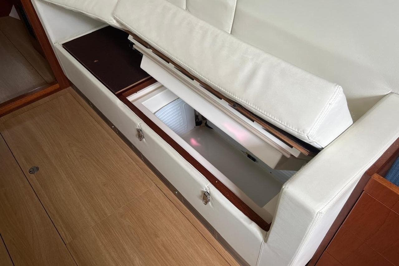 Interior storage compartment on 2016 Amel 55 yacht, featuring white cushioned seating.