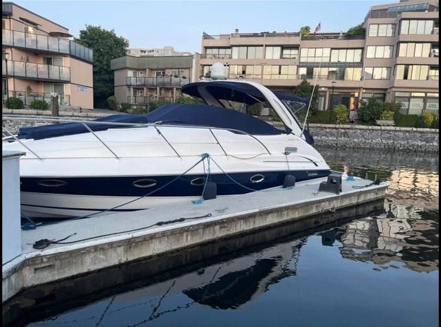 2008 Doral Elegante boat docked near modern waterfront buildings.